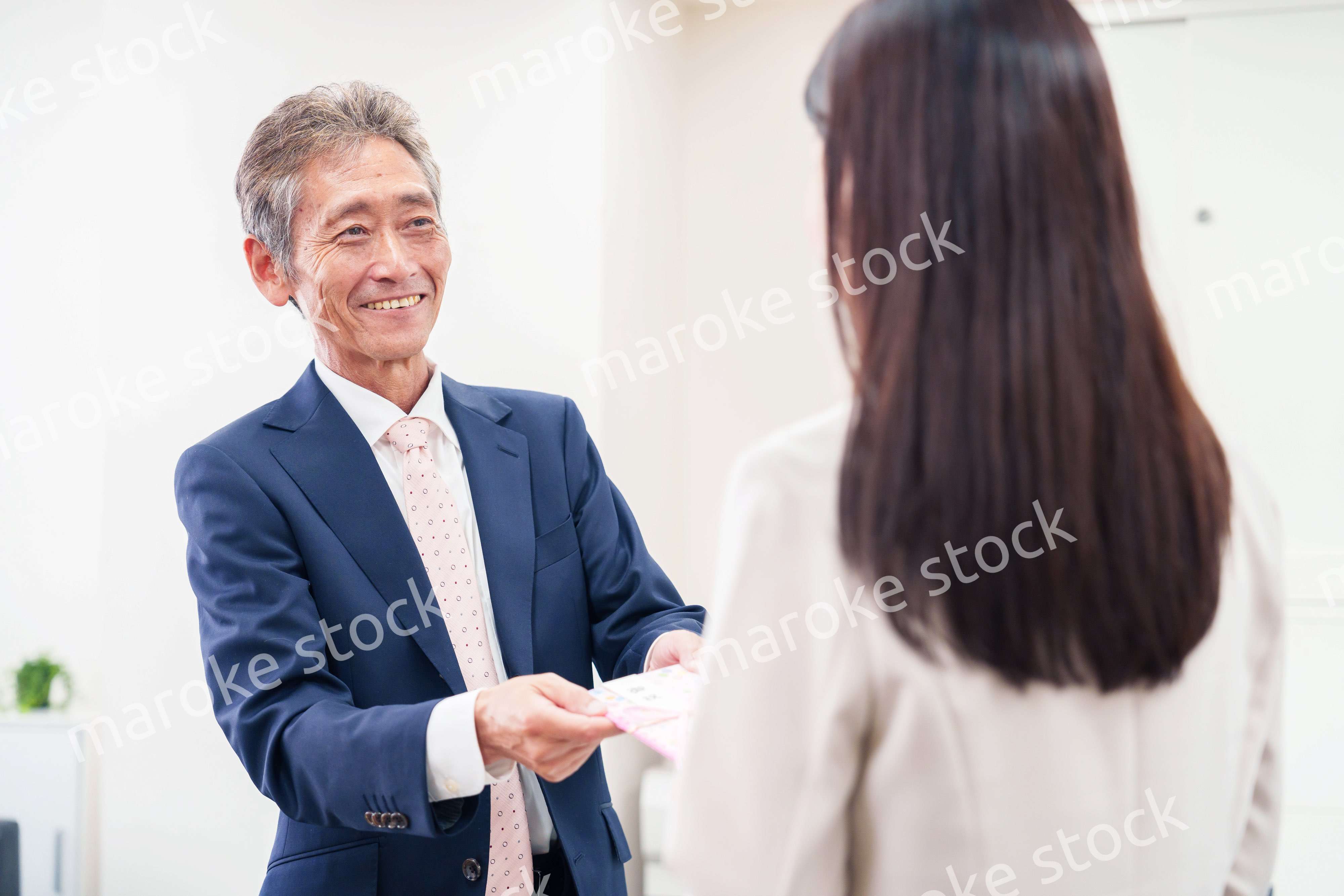 上司からお祝いを手渡されるビジネスウーマン