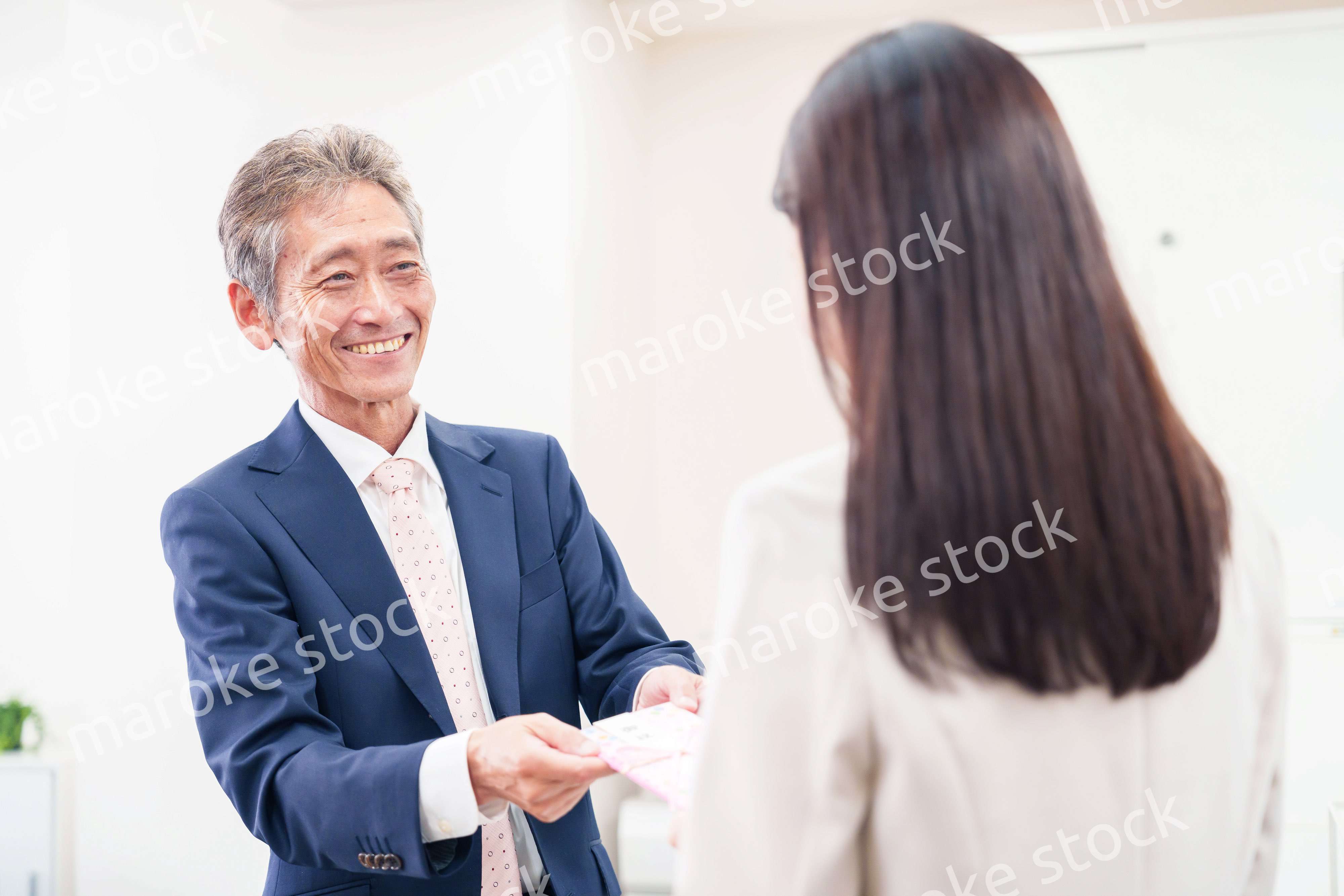 上司からお祝いを手渡されるビジネスウーマン