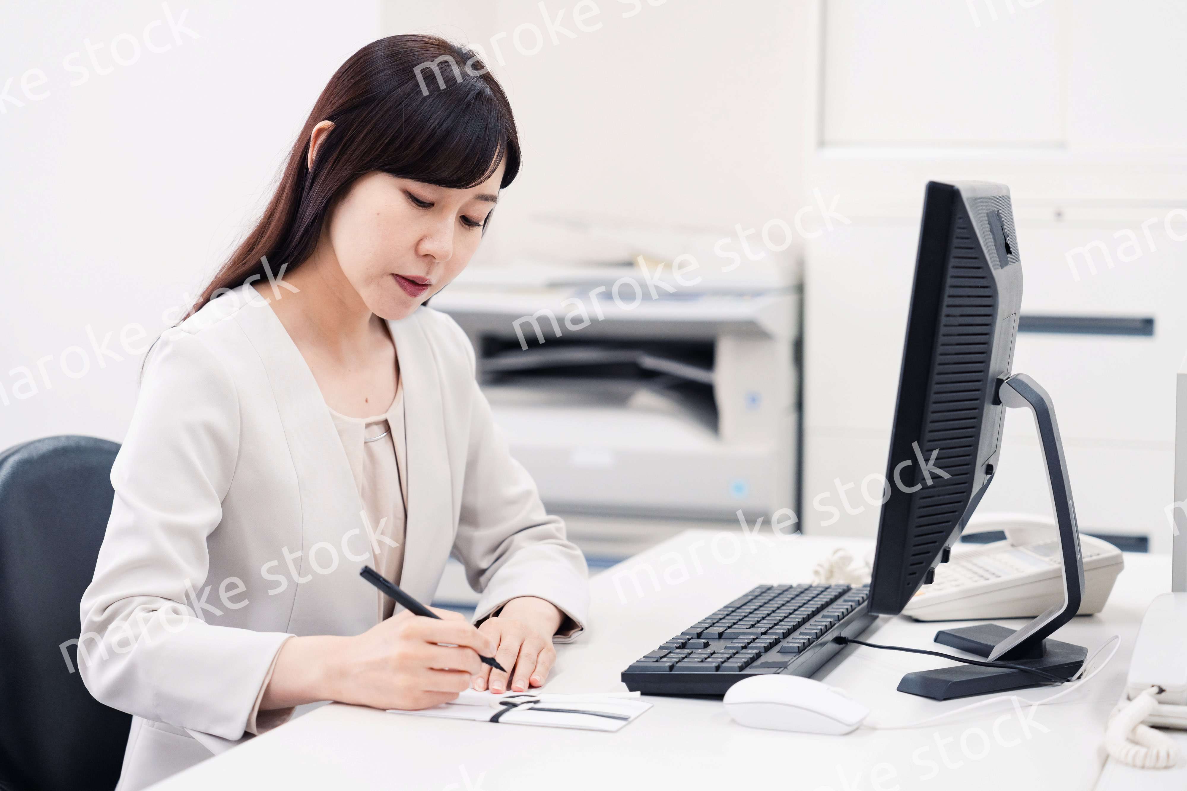 会社で葬儀の準備をする女性