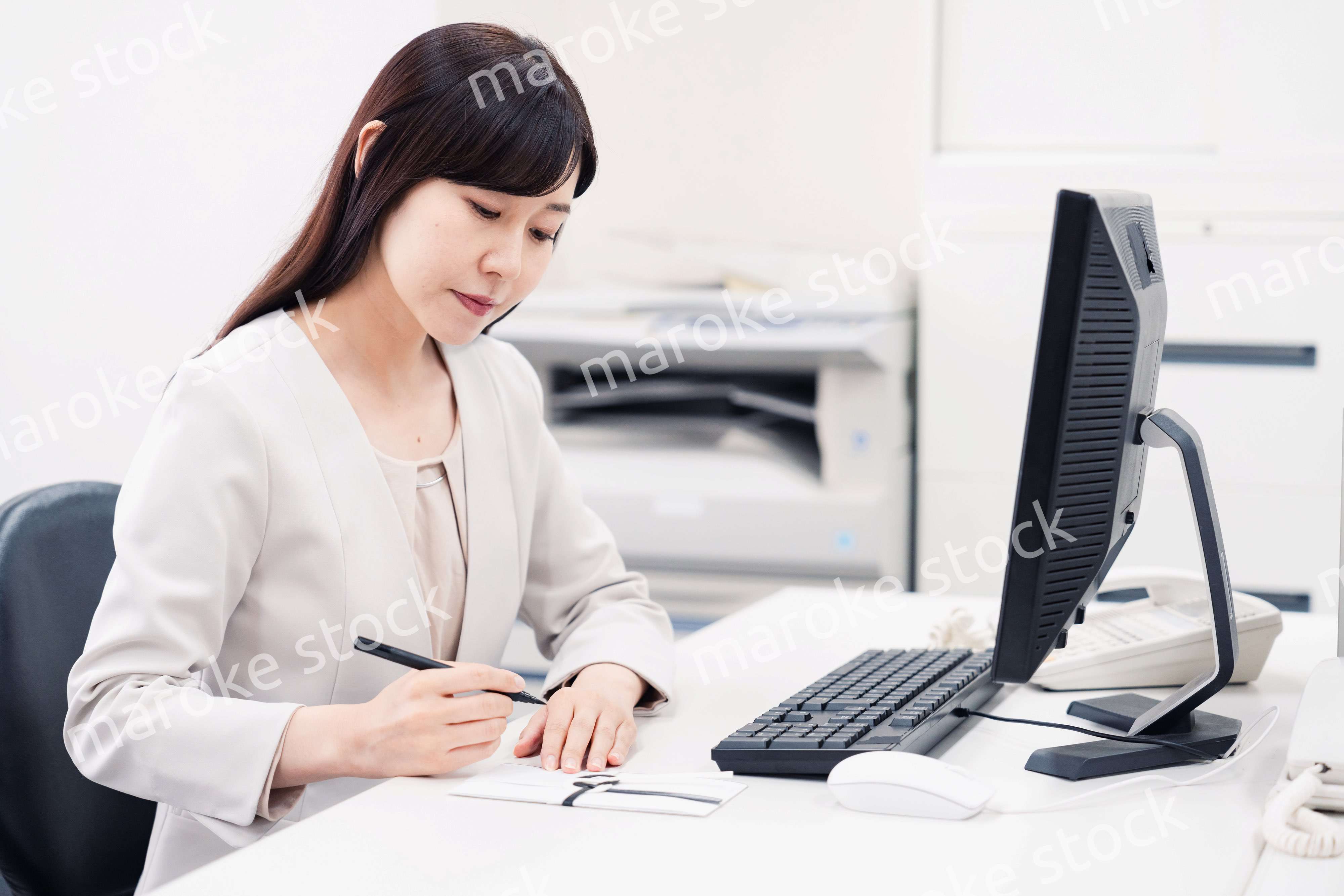 会社で葬儀の準備をする女性