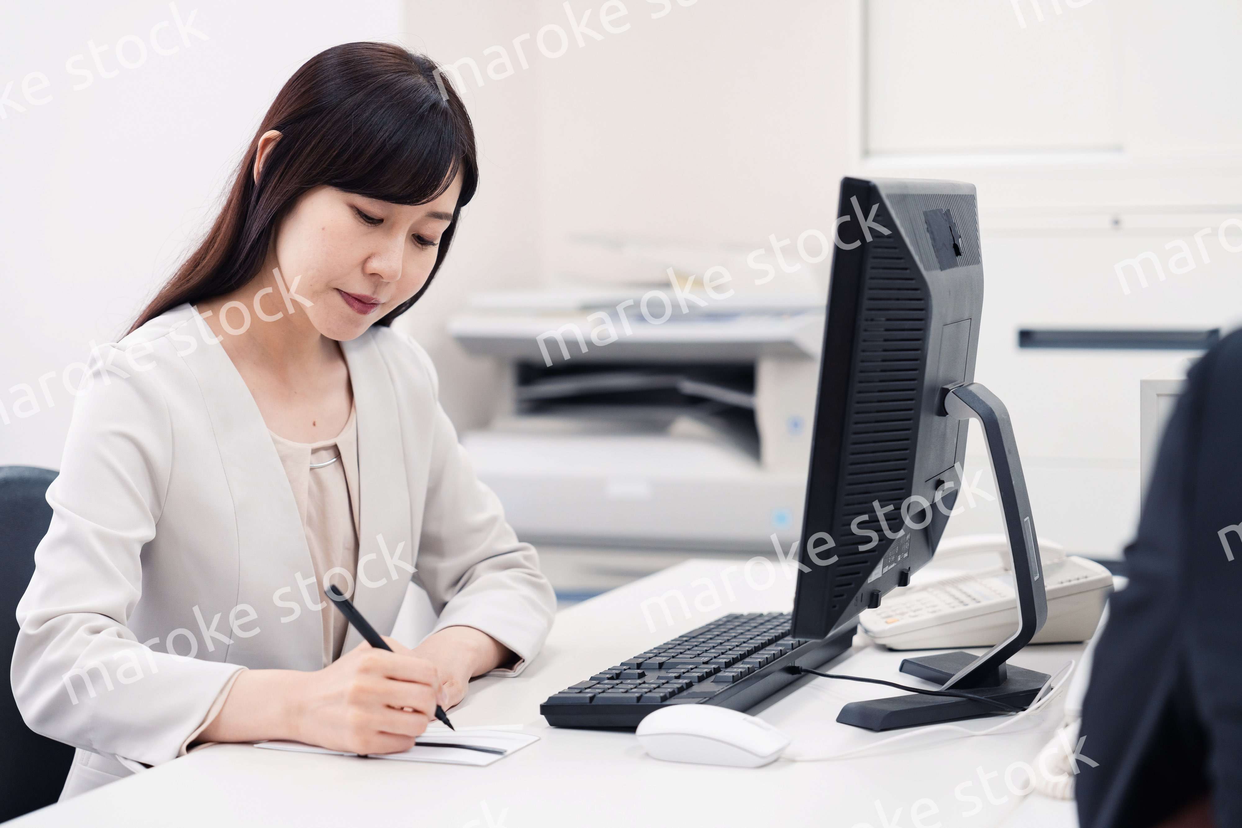 会社で葬儀の準備をする女性