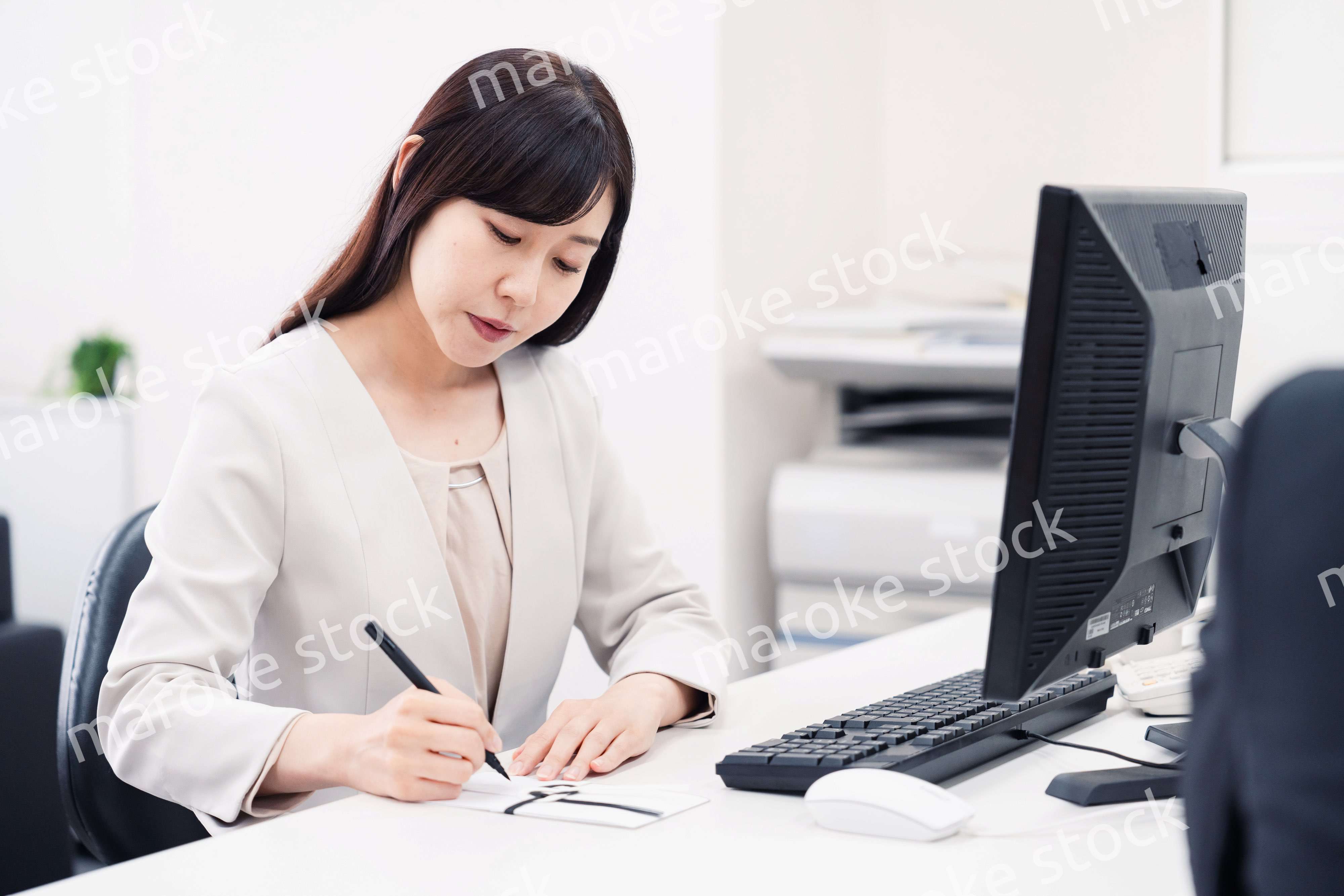 会社で葬儀の準備をする女性