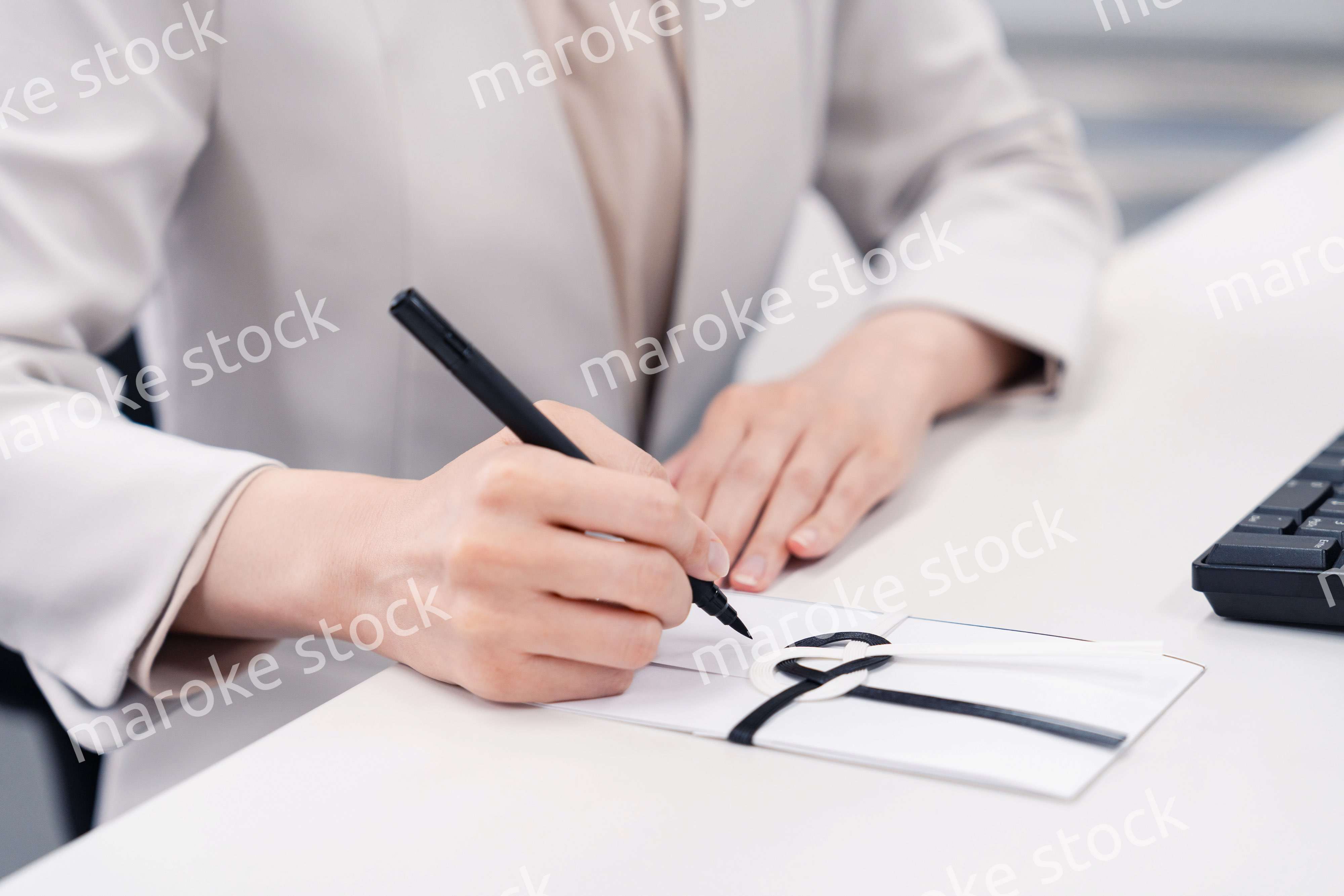 会社で葬儀の準備をする女性