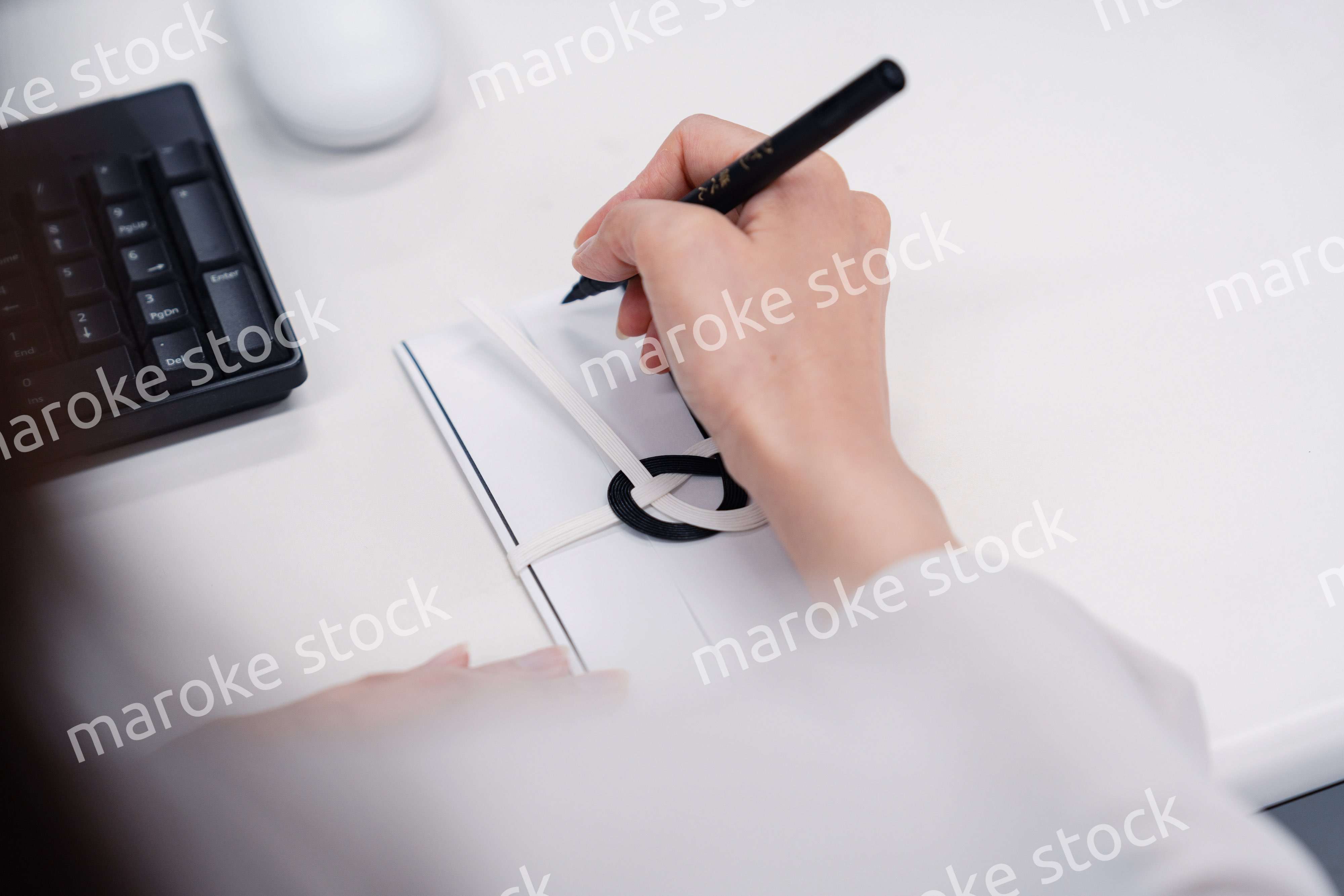 会社で葬儀の準備をする女性