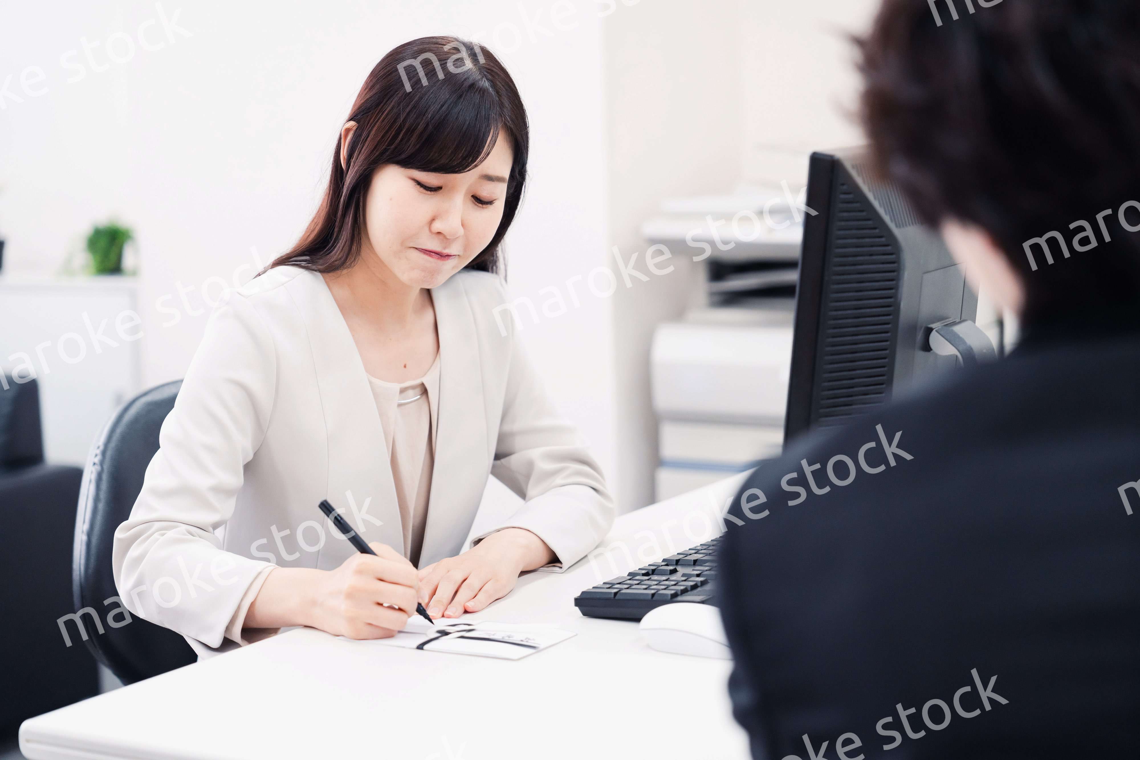 会社で葬儀の準備をする女性