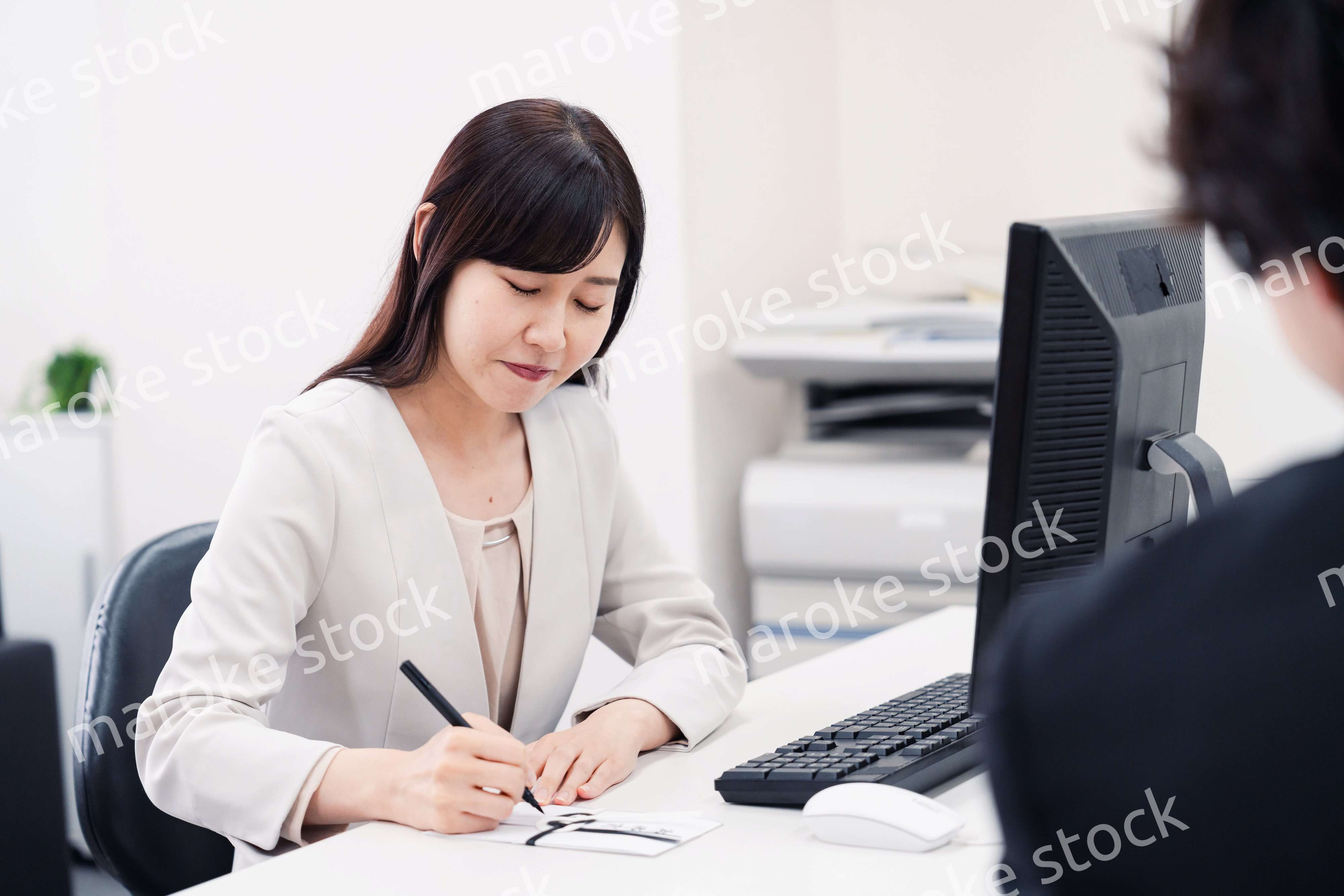 会社で葬儀の準備をする女性