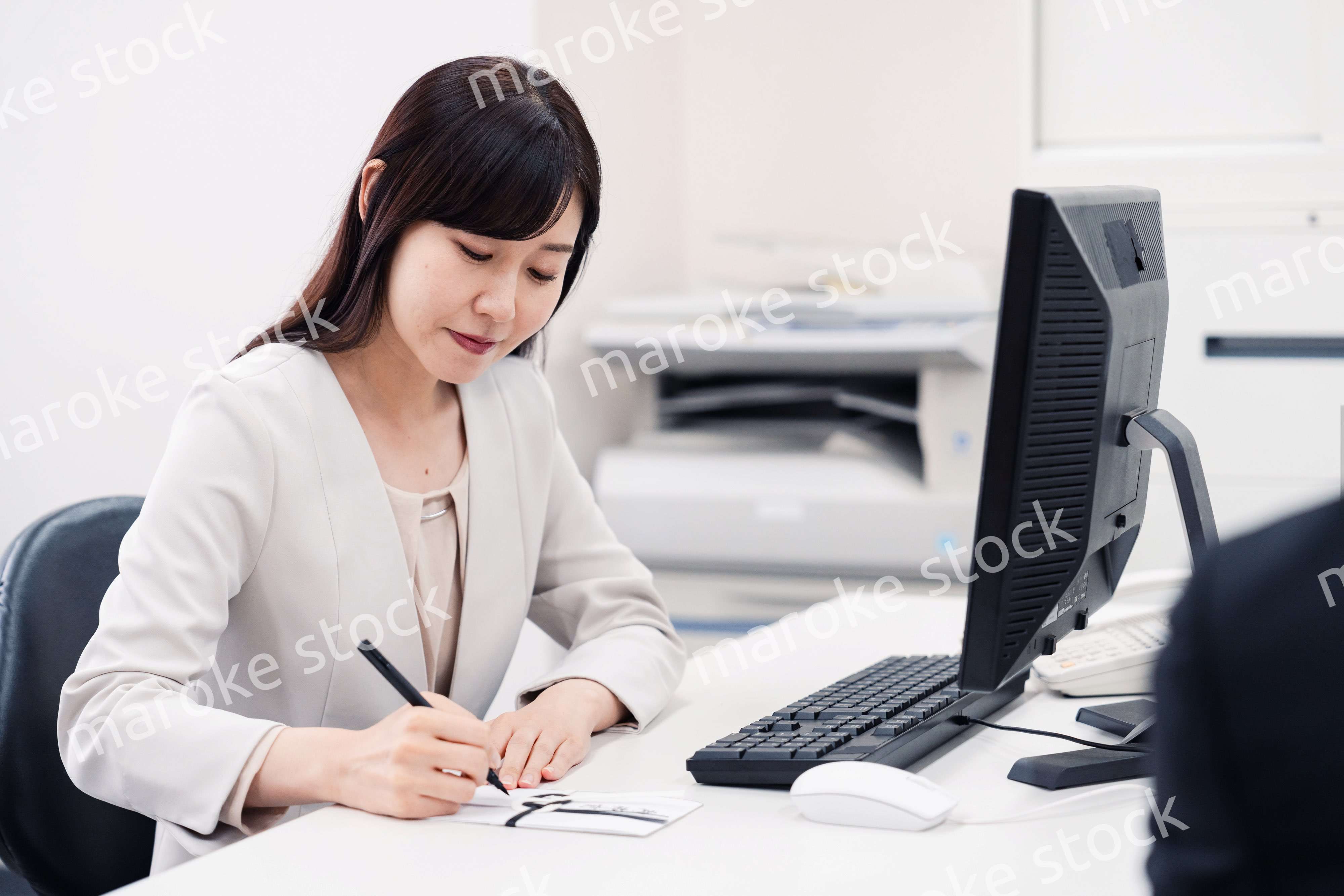 会社で葬儀の準備をする女性