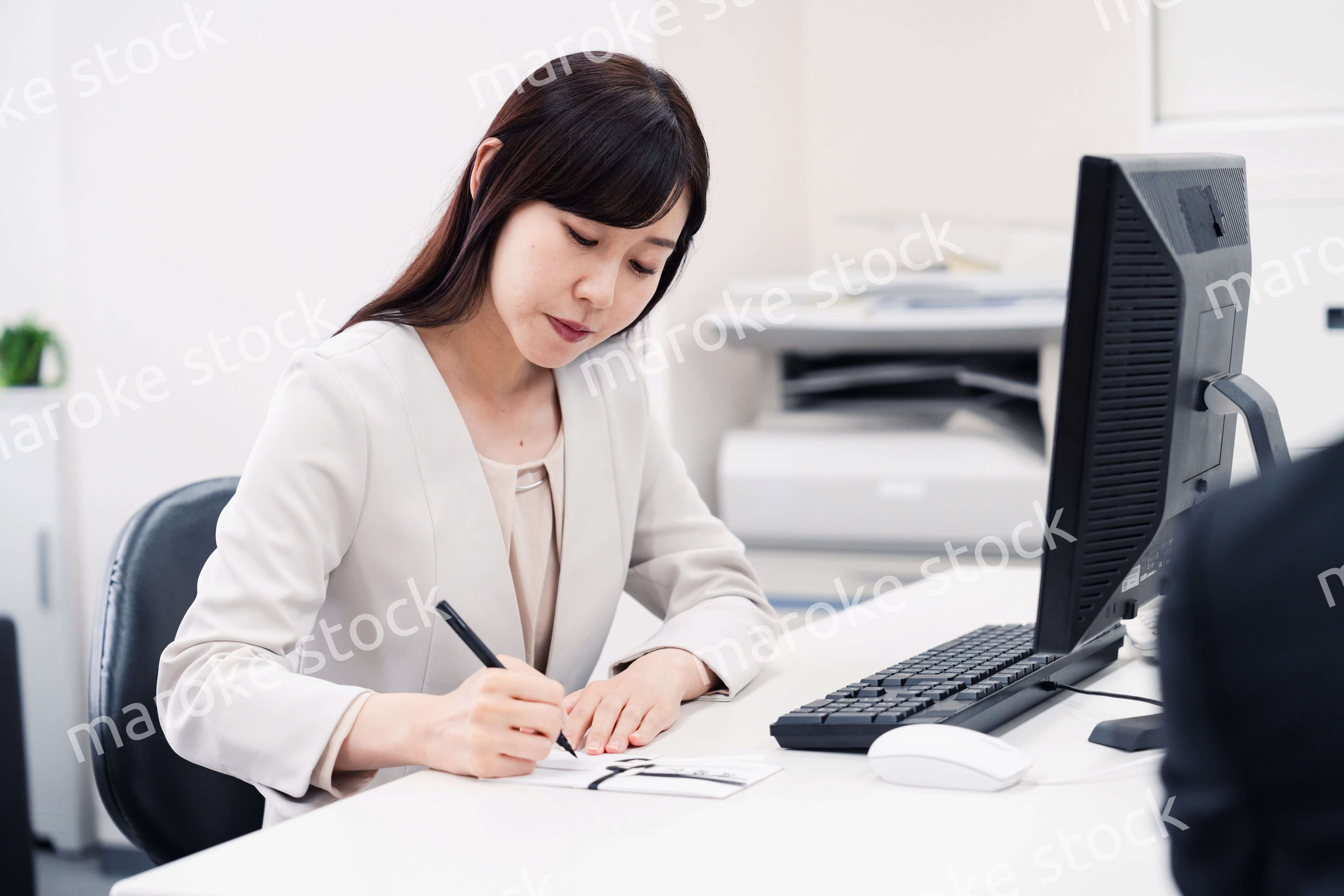 会社で葬儀の準備をする女性