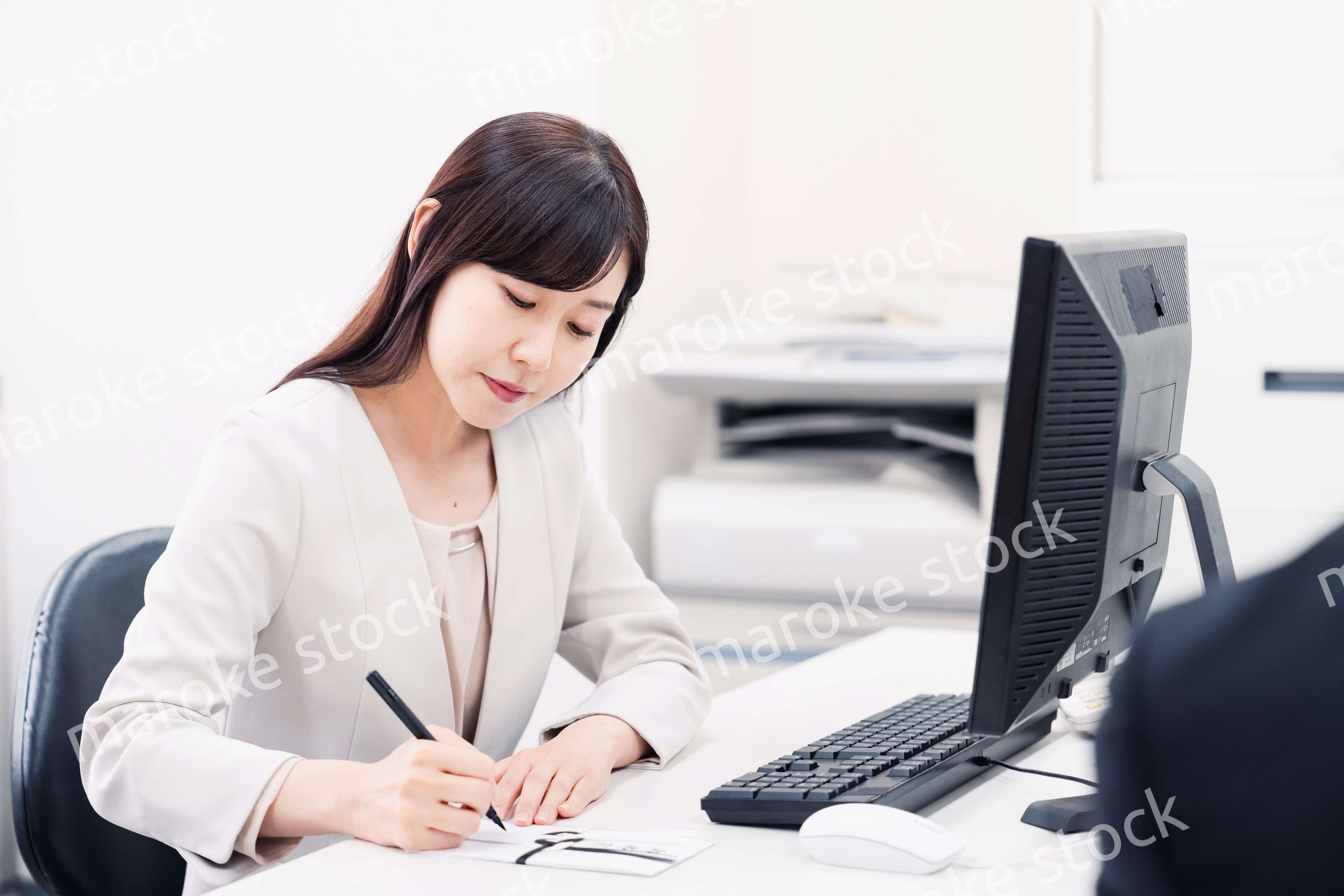 会社で葬儀の準備をする女性