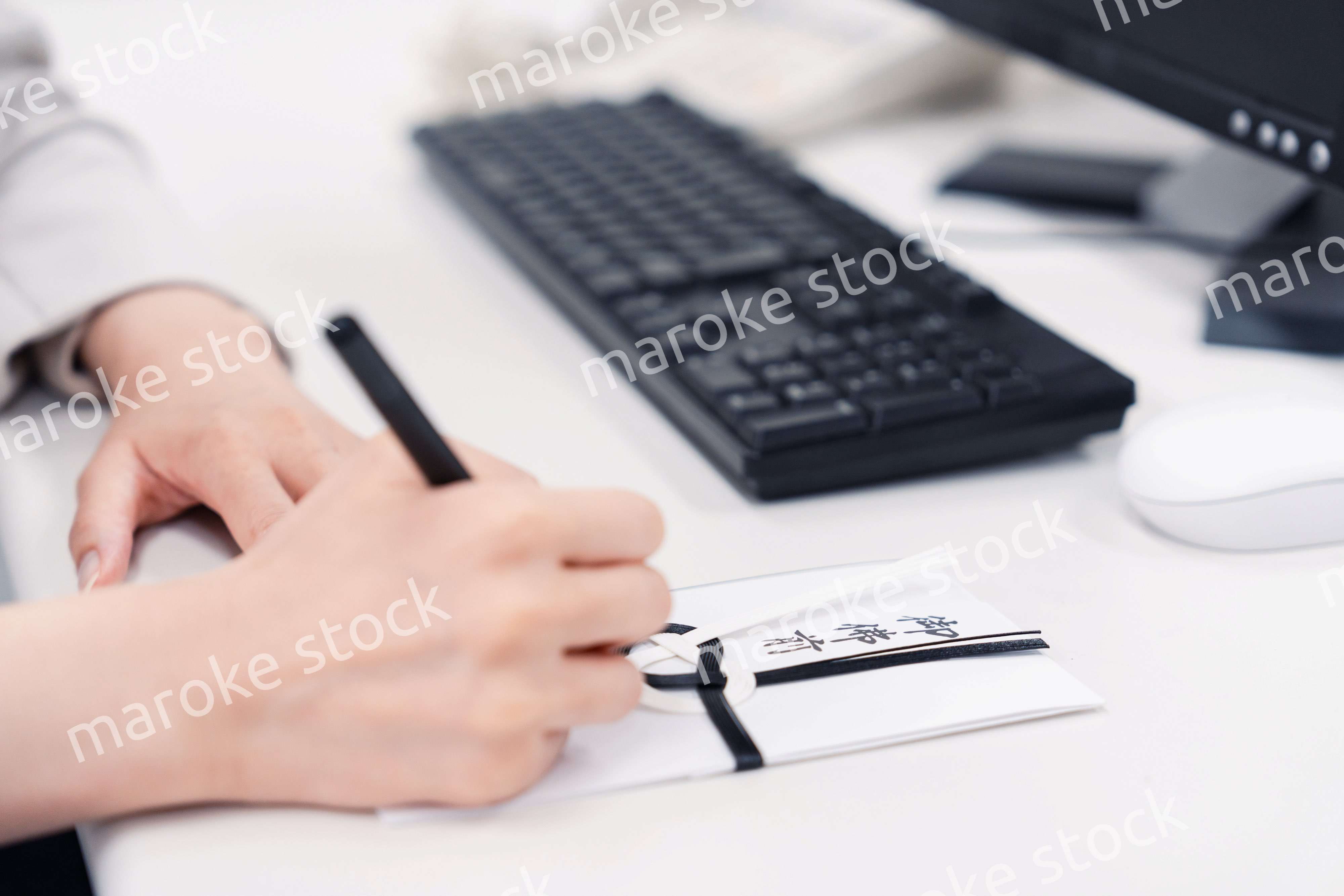 会社で葬儀の準備をする女性