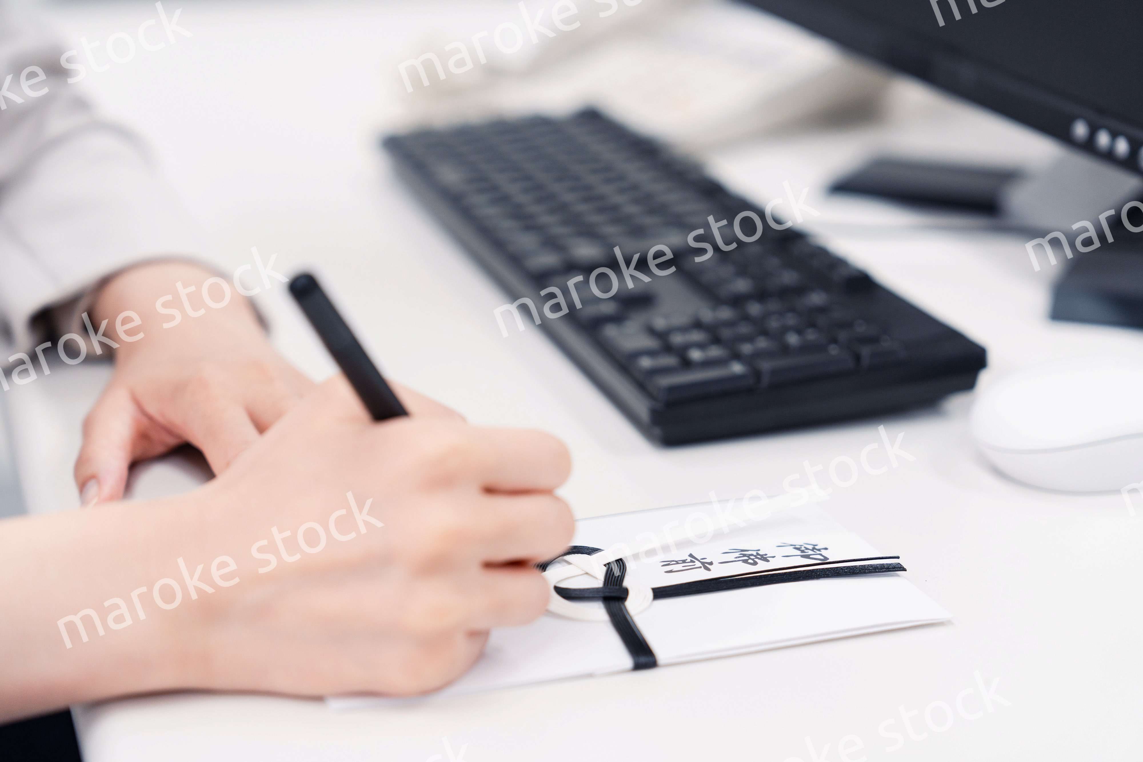 会社で葬儀の準備をする女性