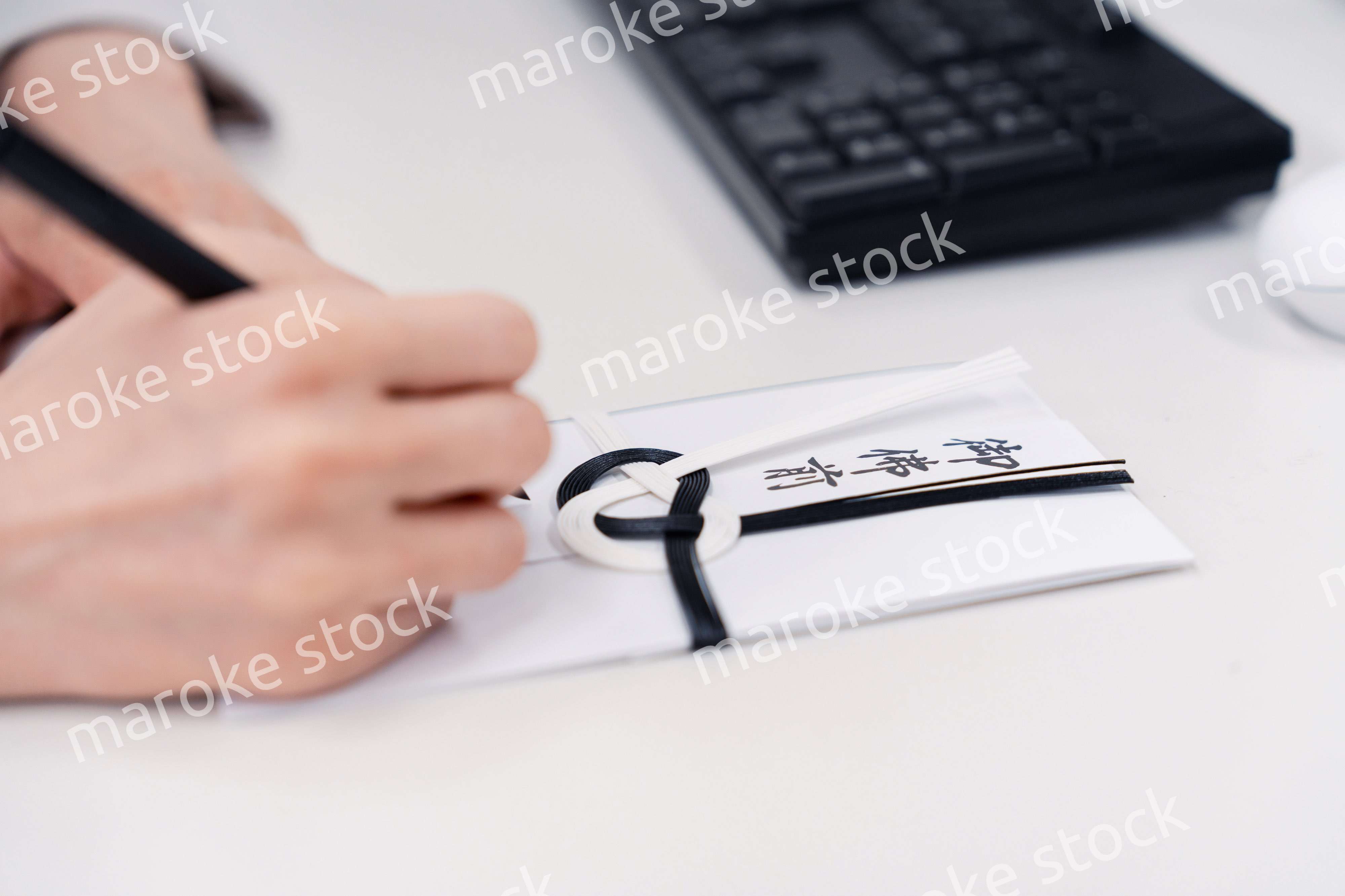 会社で葬儀の準備をする女性