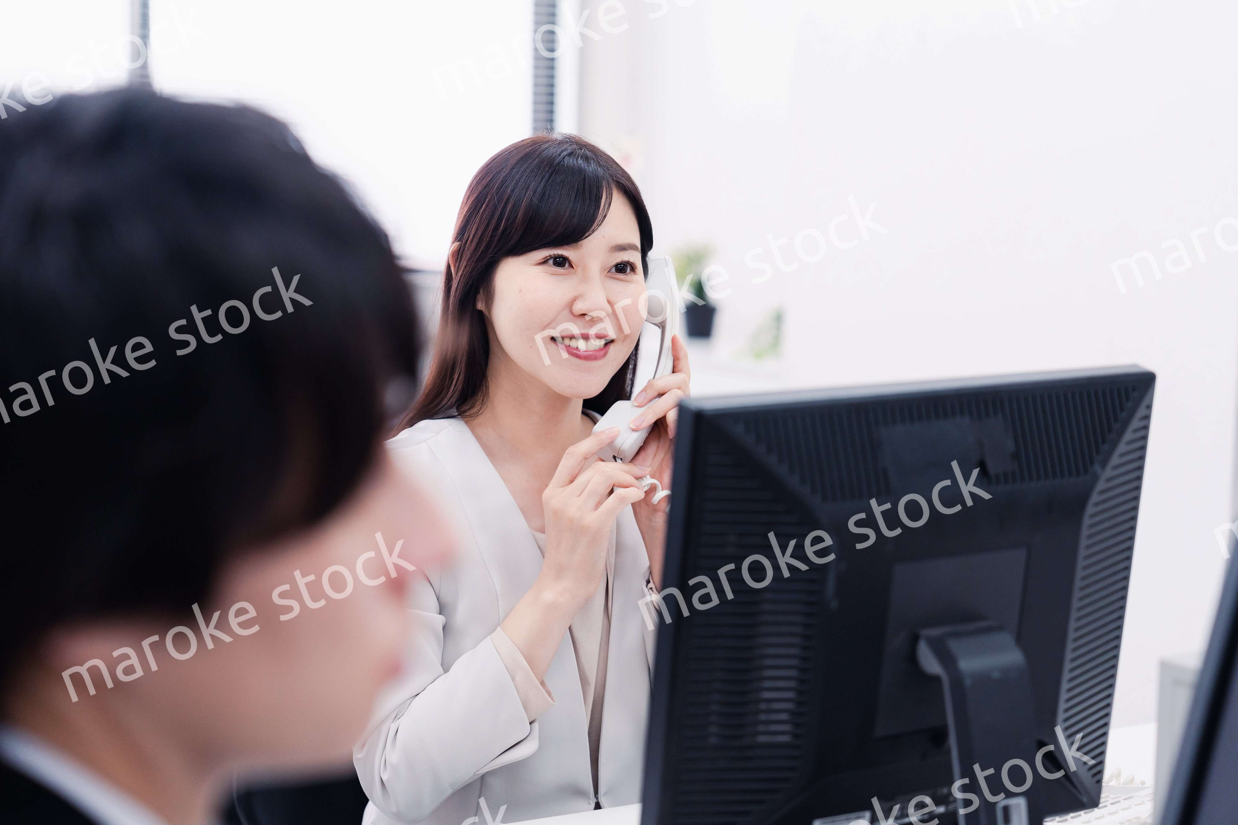 オフィスで電話対応をする女性社員