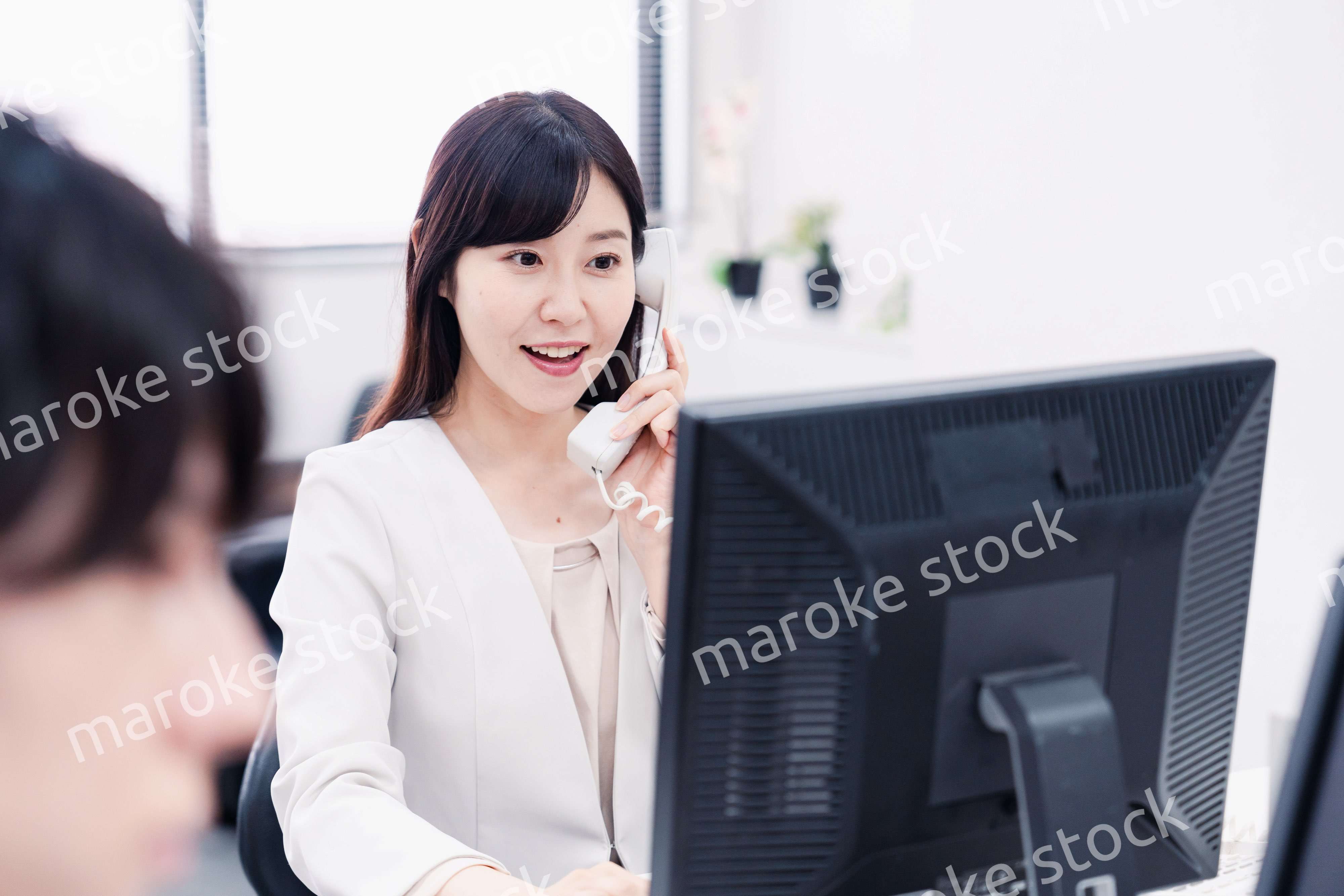 オフィスで電話対応をする女性社員