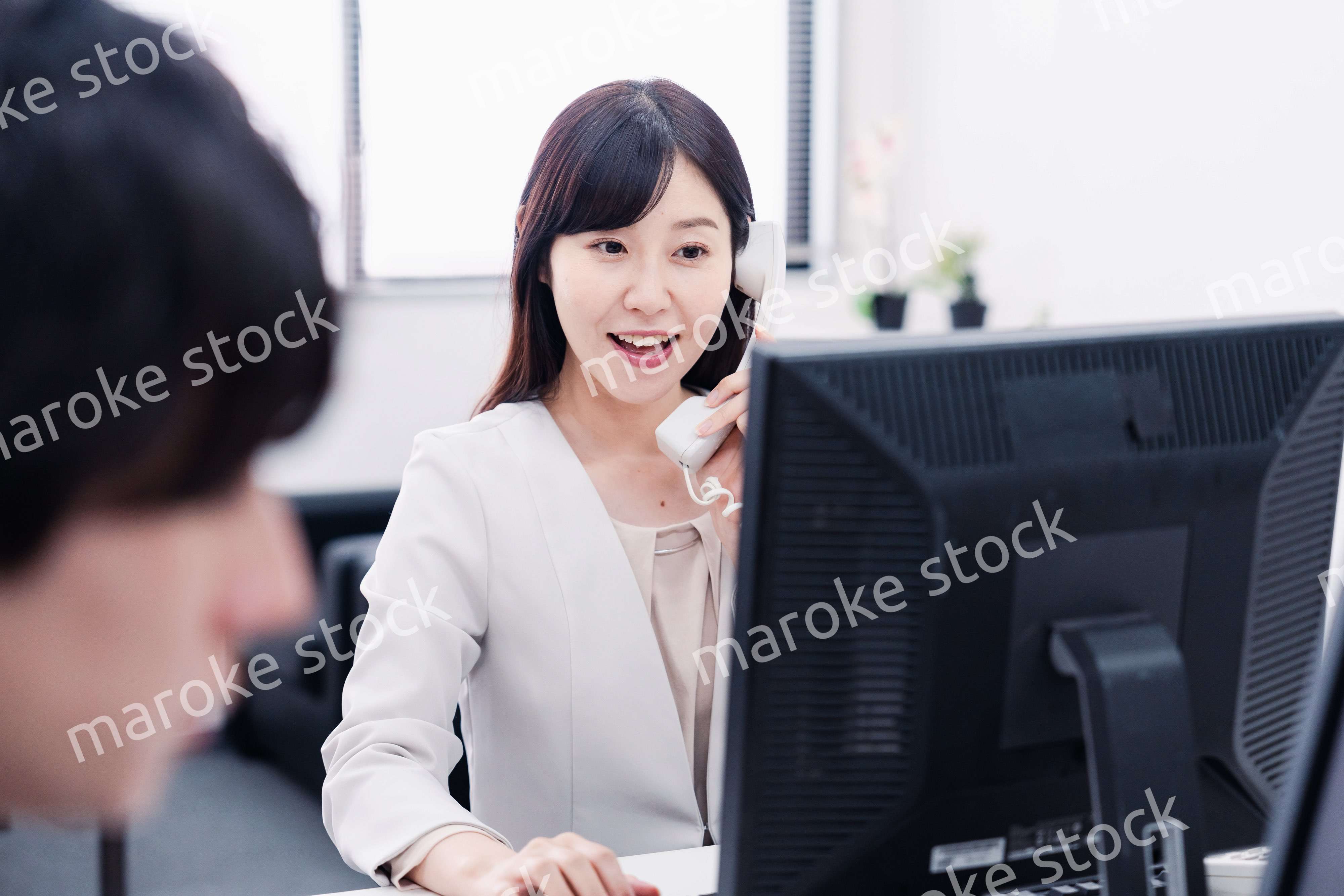 オフィスで電話対応をする女性社員