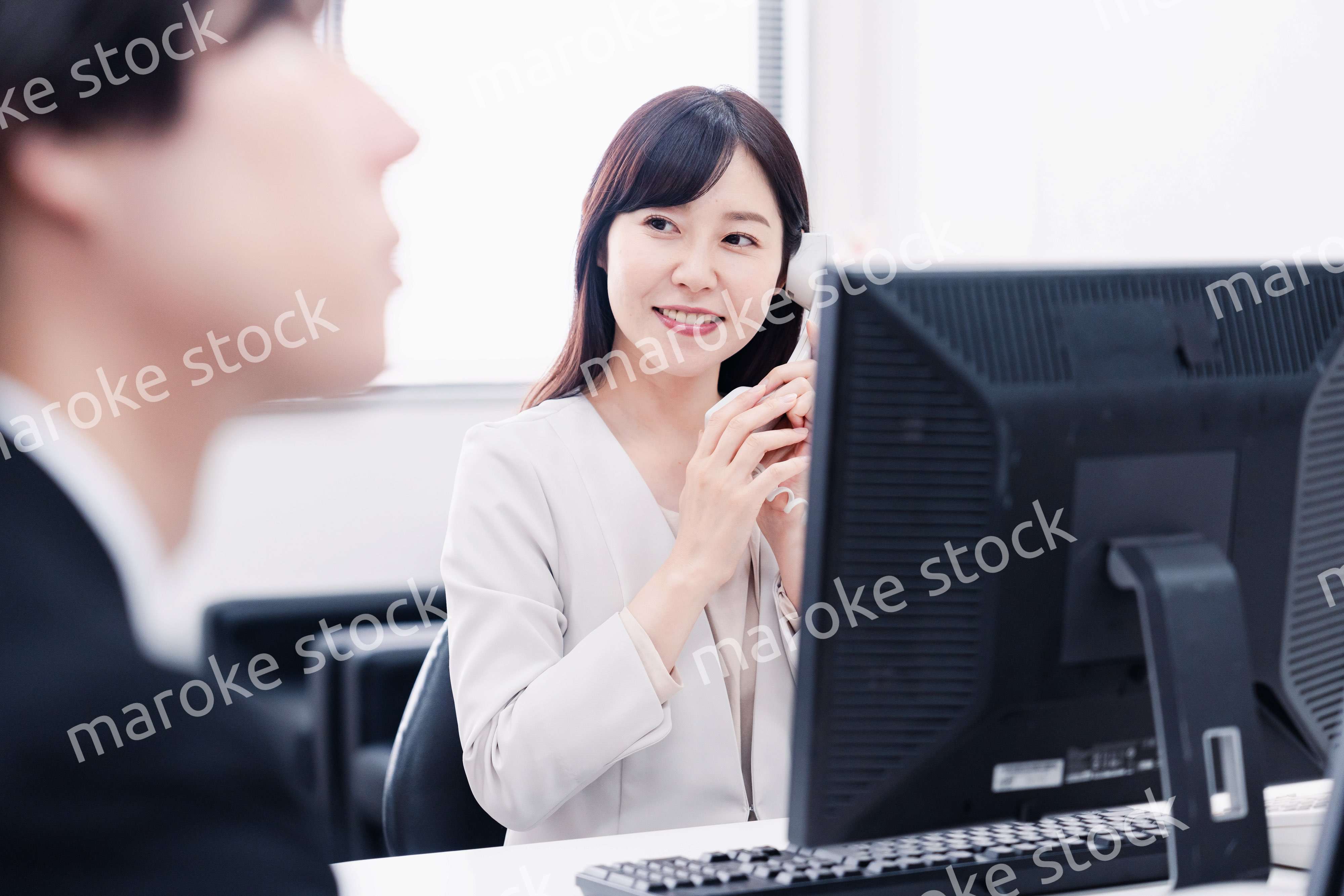 オフィスで電話対応をする女性社員