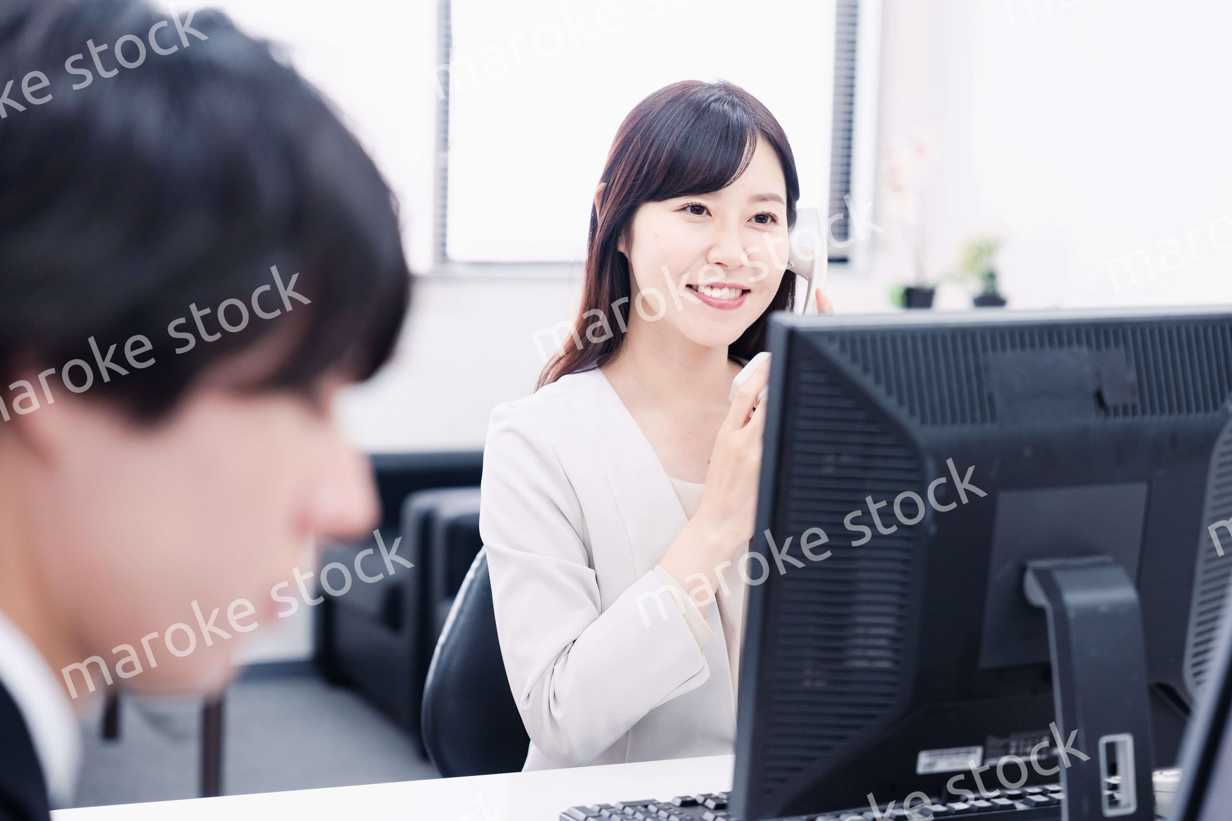 オフィスで電話対応をする女性社員