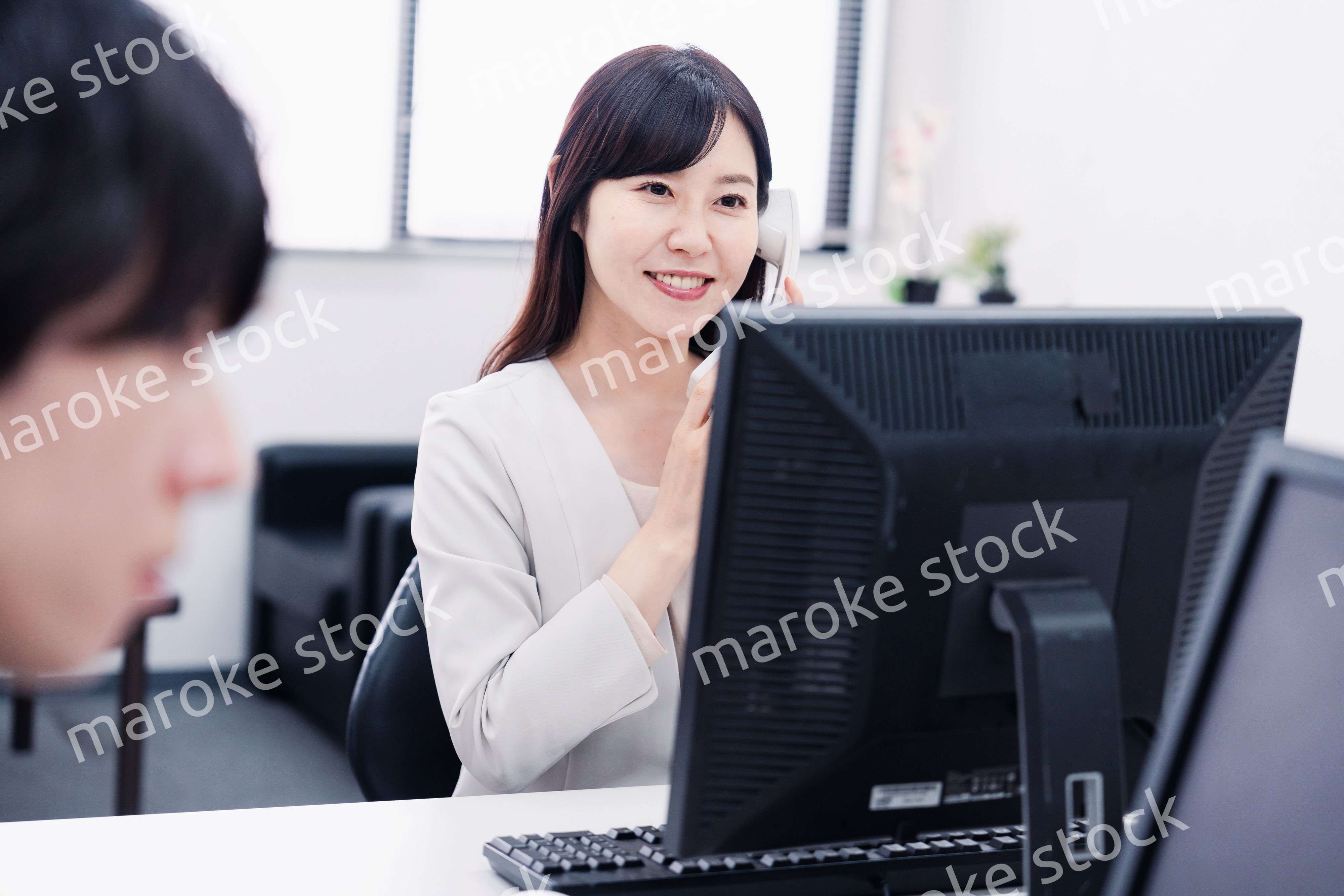 オフィスで電話対応をする女性社員