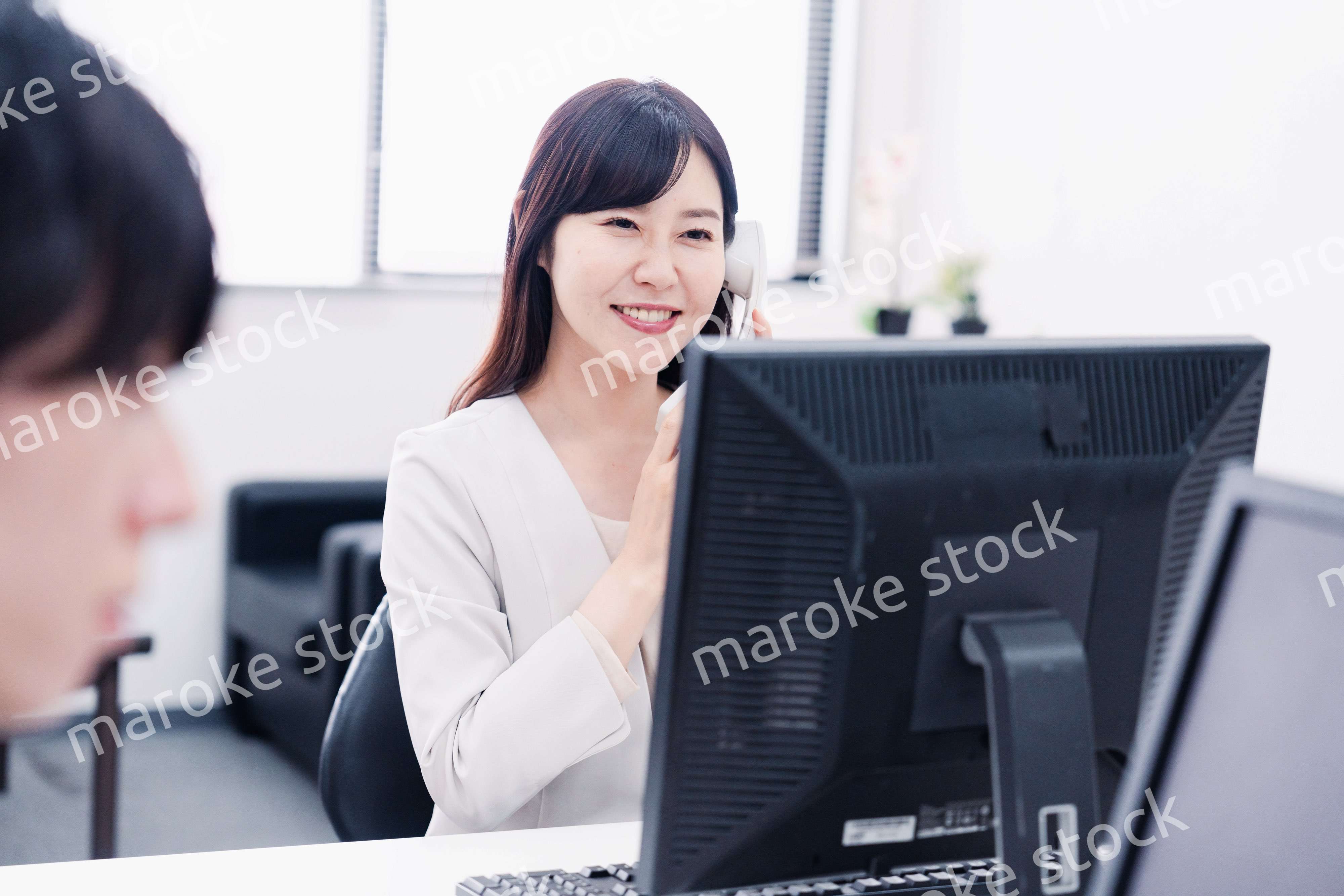 オフィスで電話対応をする女性社員