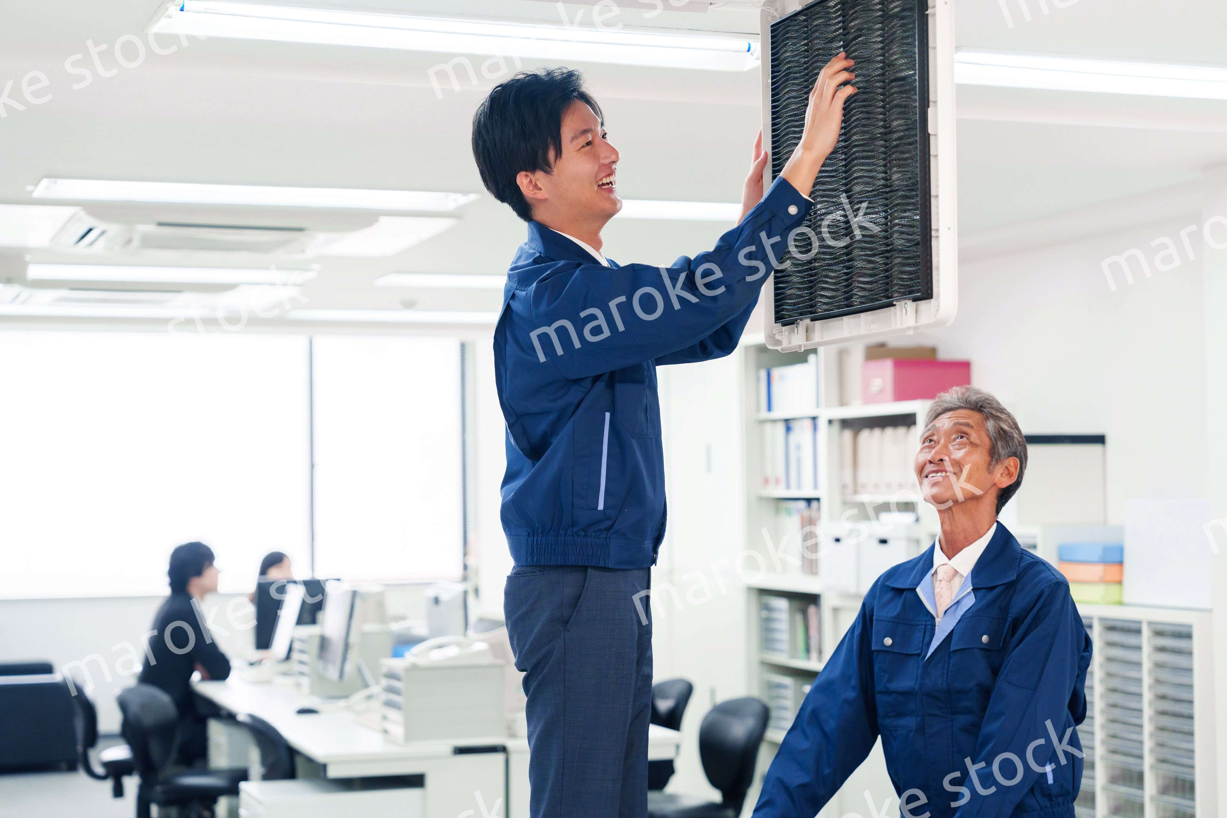 ビルのエアコンの点検をする作業服の男性