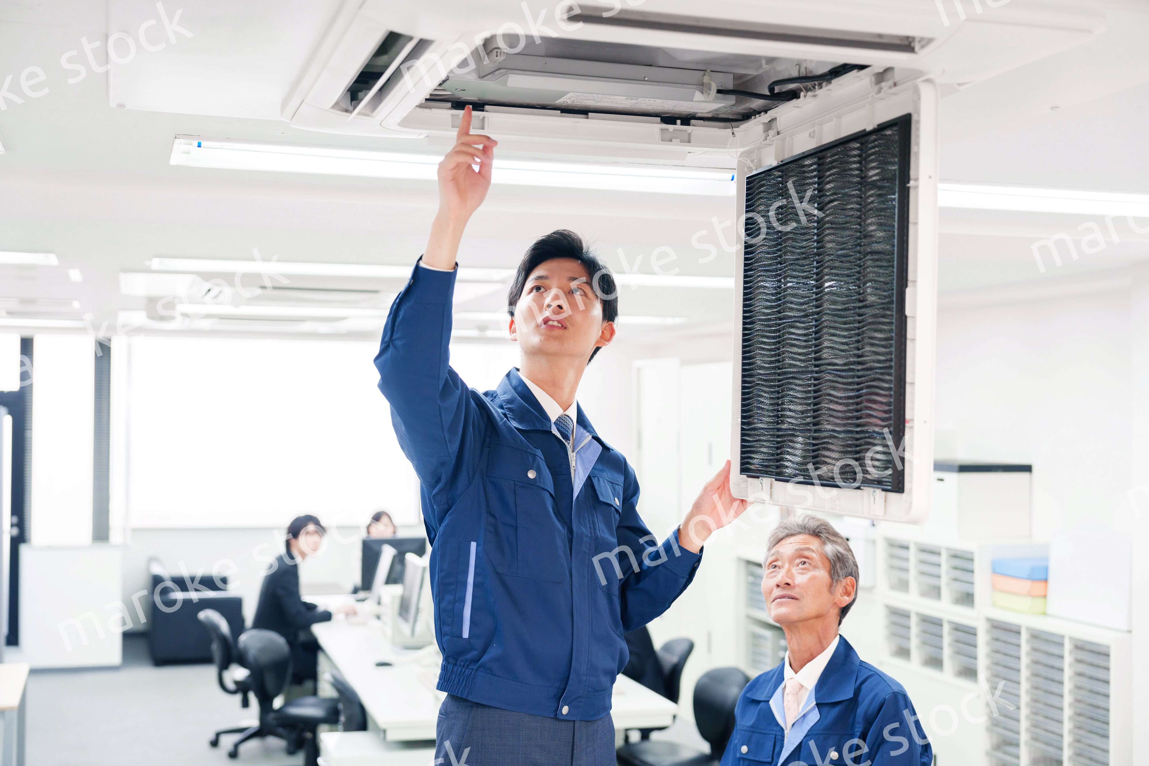 ビルのエアコンの点検をする作業服の男性