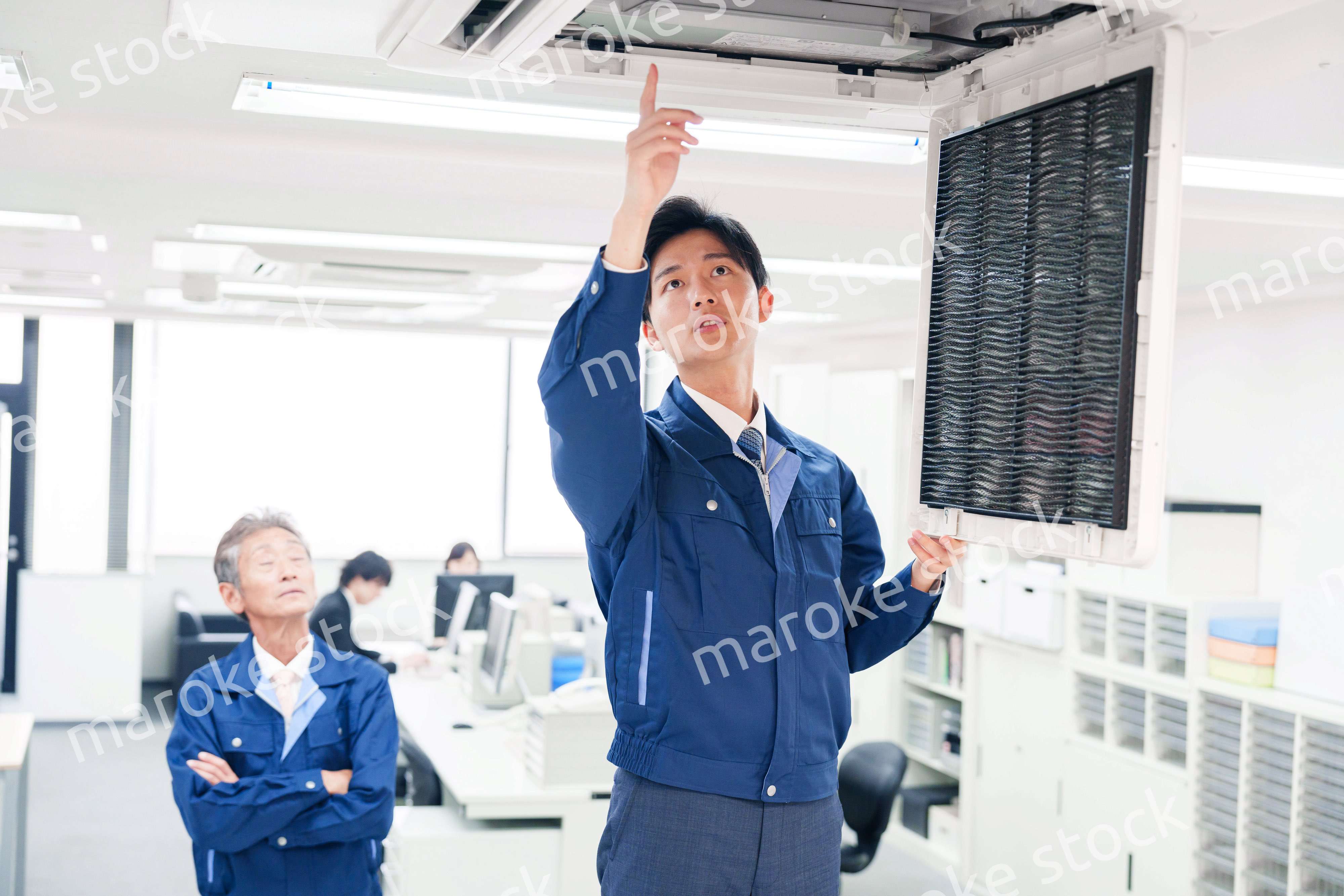 ビルのエアコンの点検をする作業服の男性