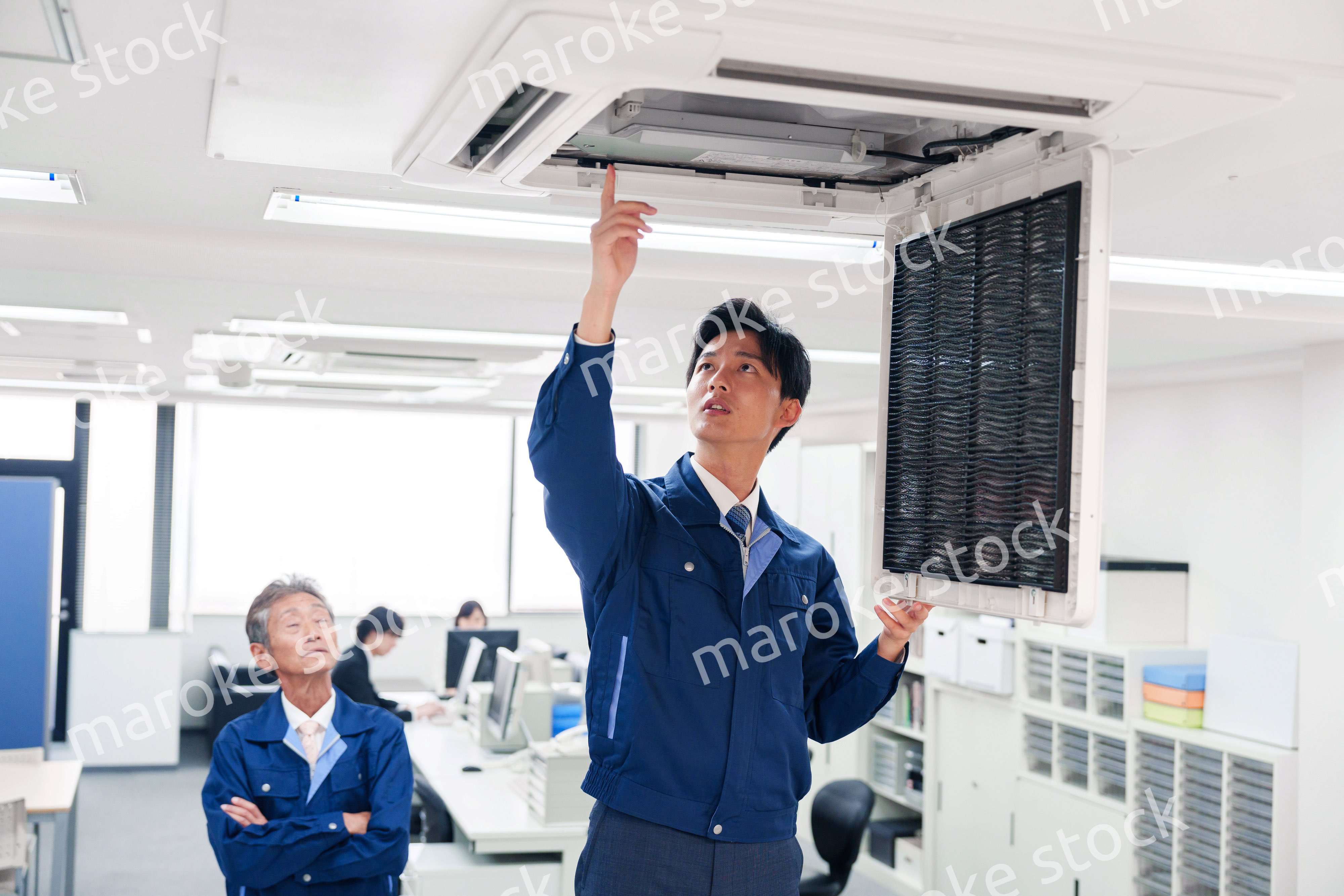 ビルのエアコンの点検をする作業服の男性