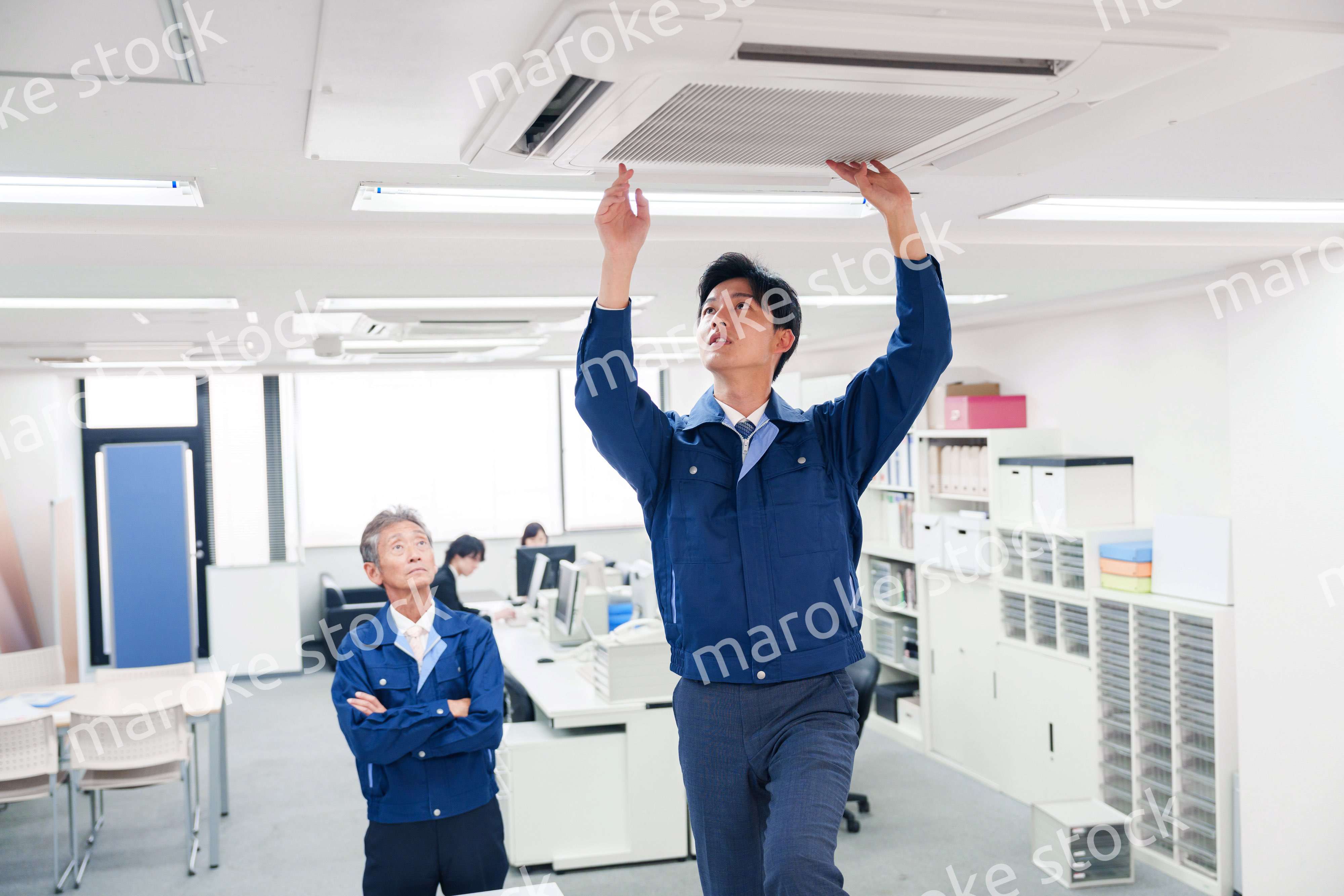 ビルのエアコンの点検をする作業服の男性