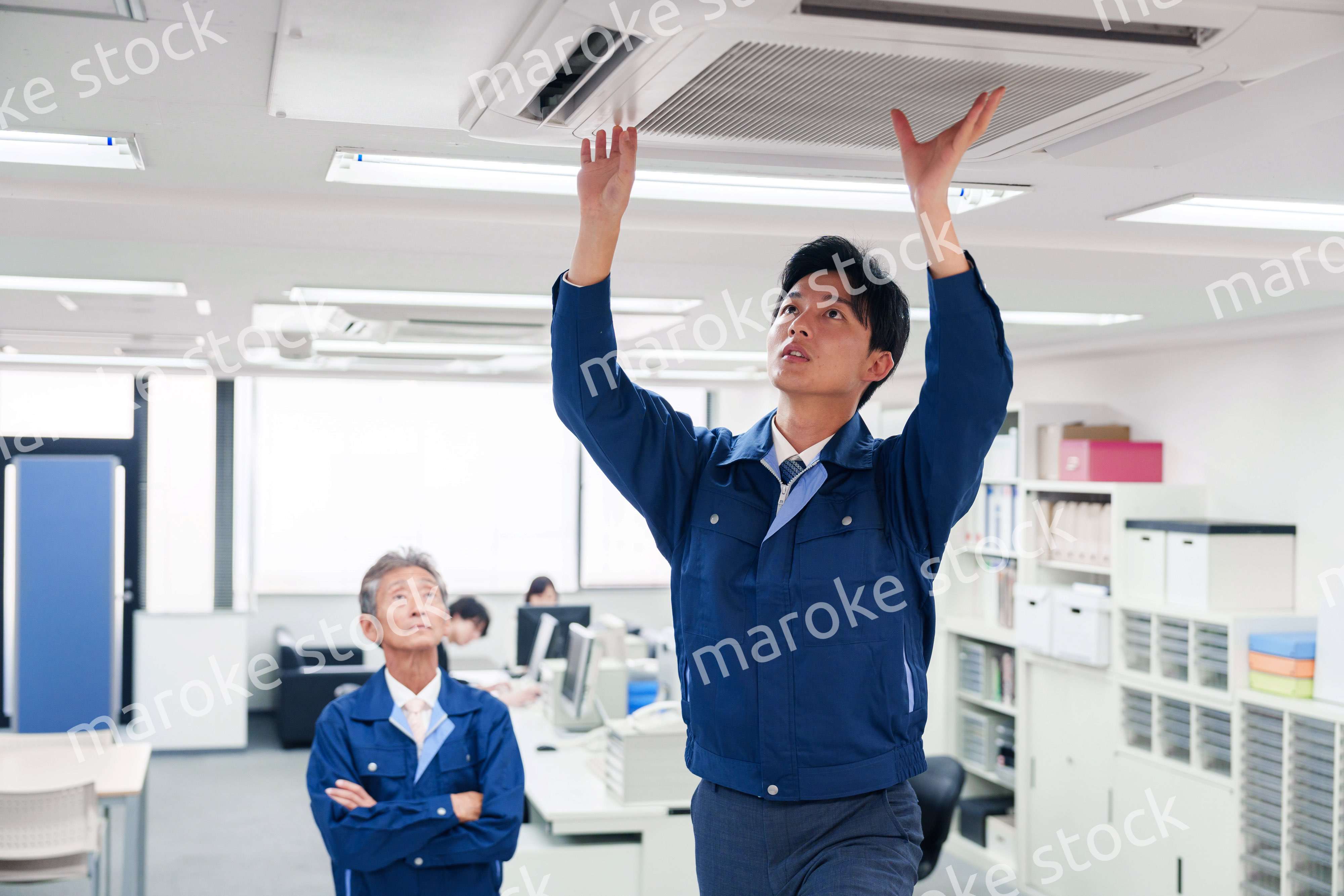 ビルのエアコンの点検をする作業服の男性