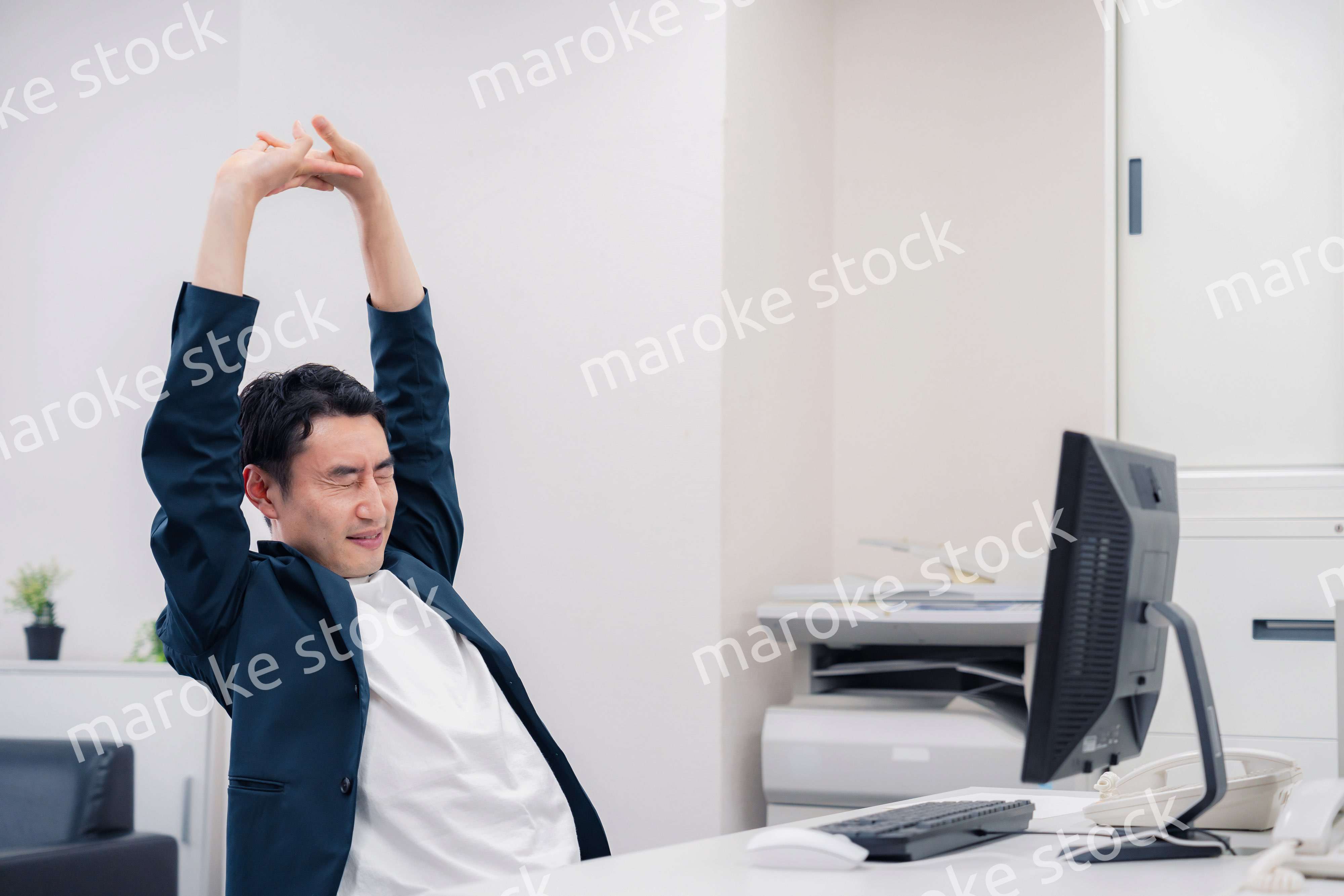 疲れて伸びをするビジネスマン