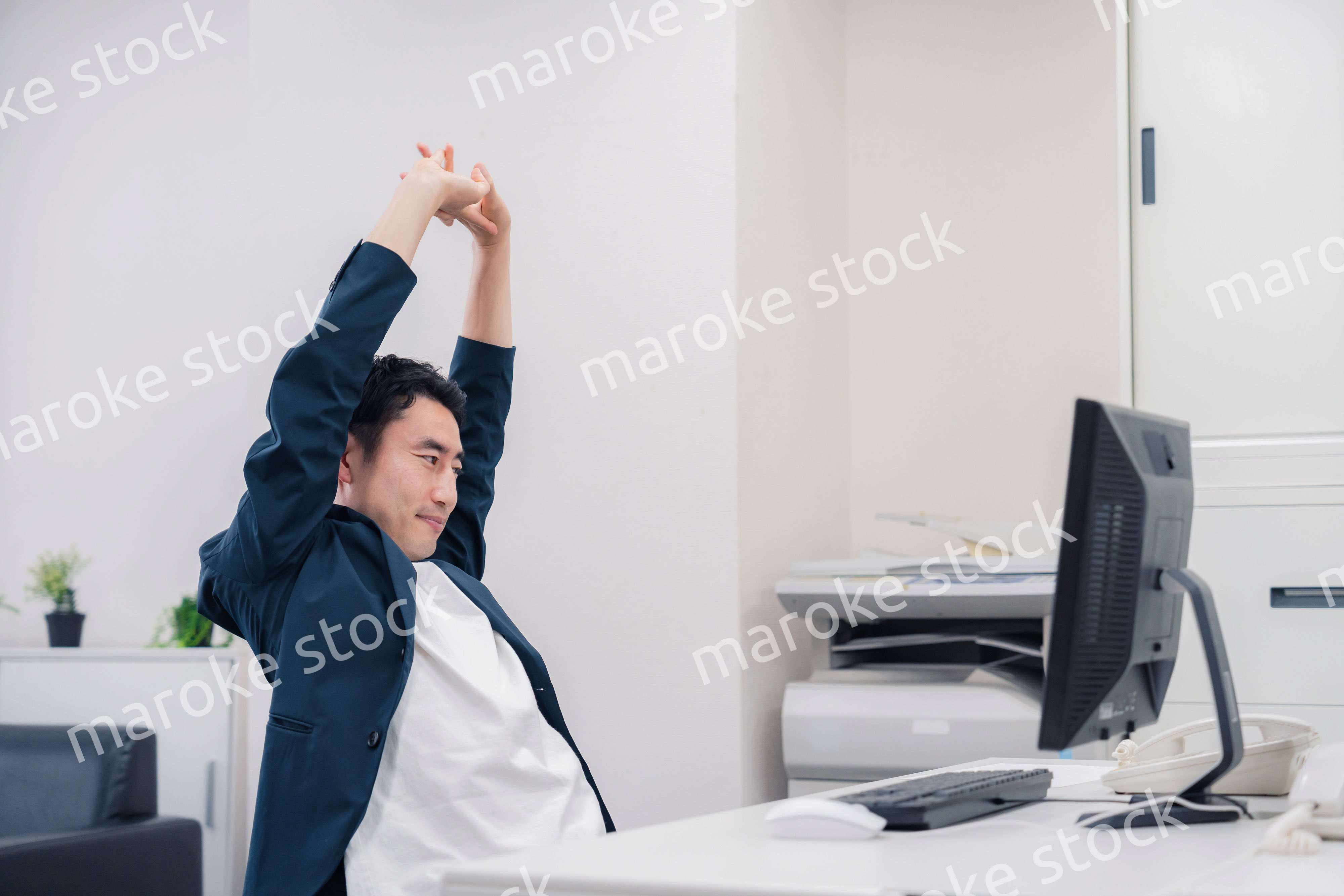 疲れて伸びをするビジネスマン