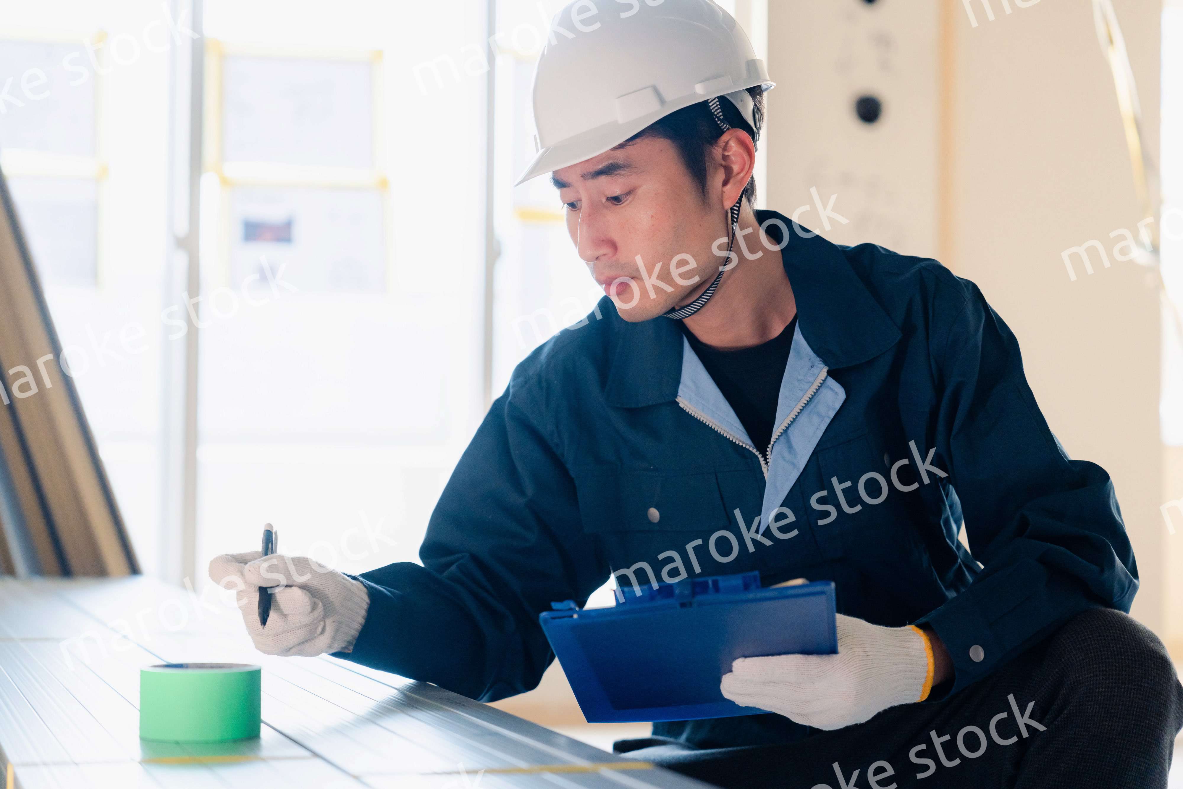 建設現場で資材の確認をする大工