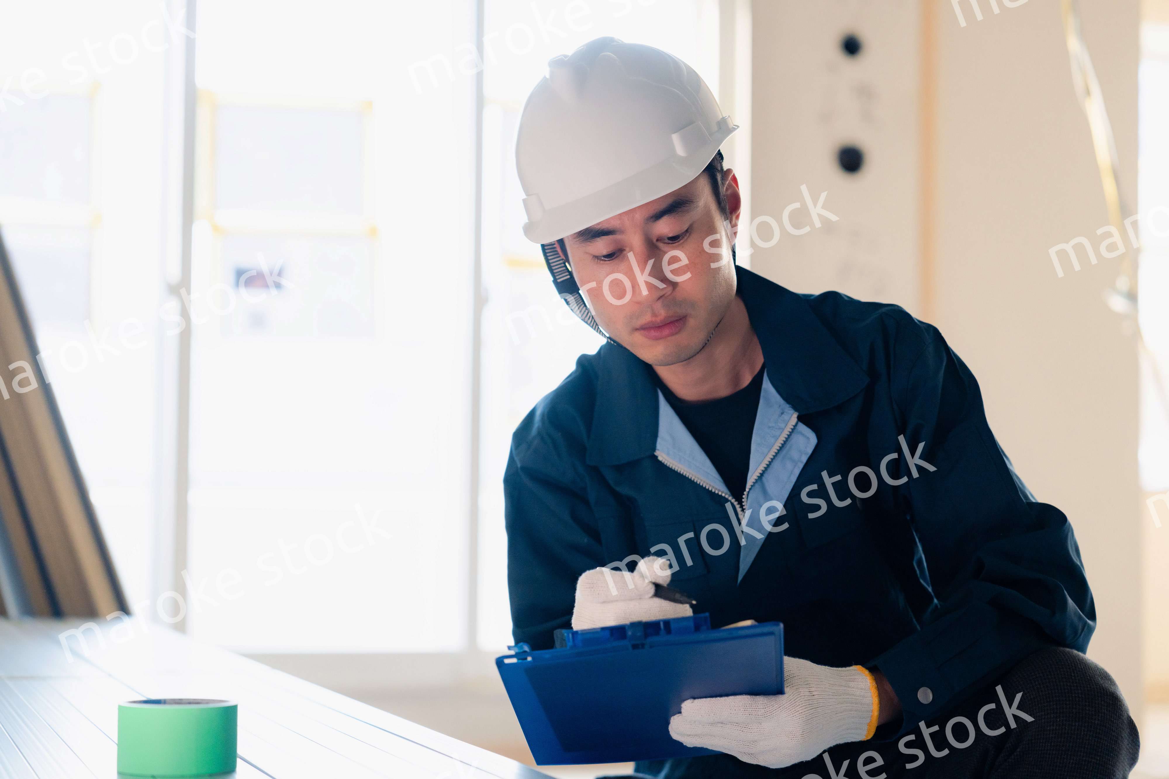 建設現場で資材の確認をする大工