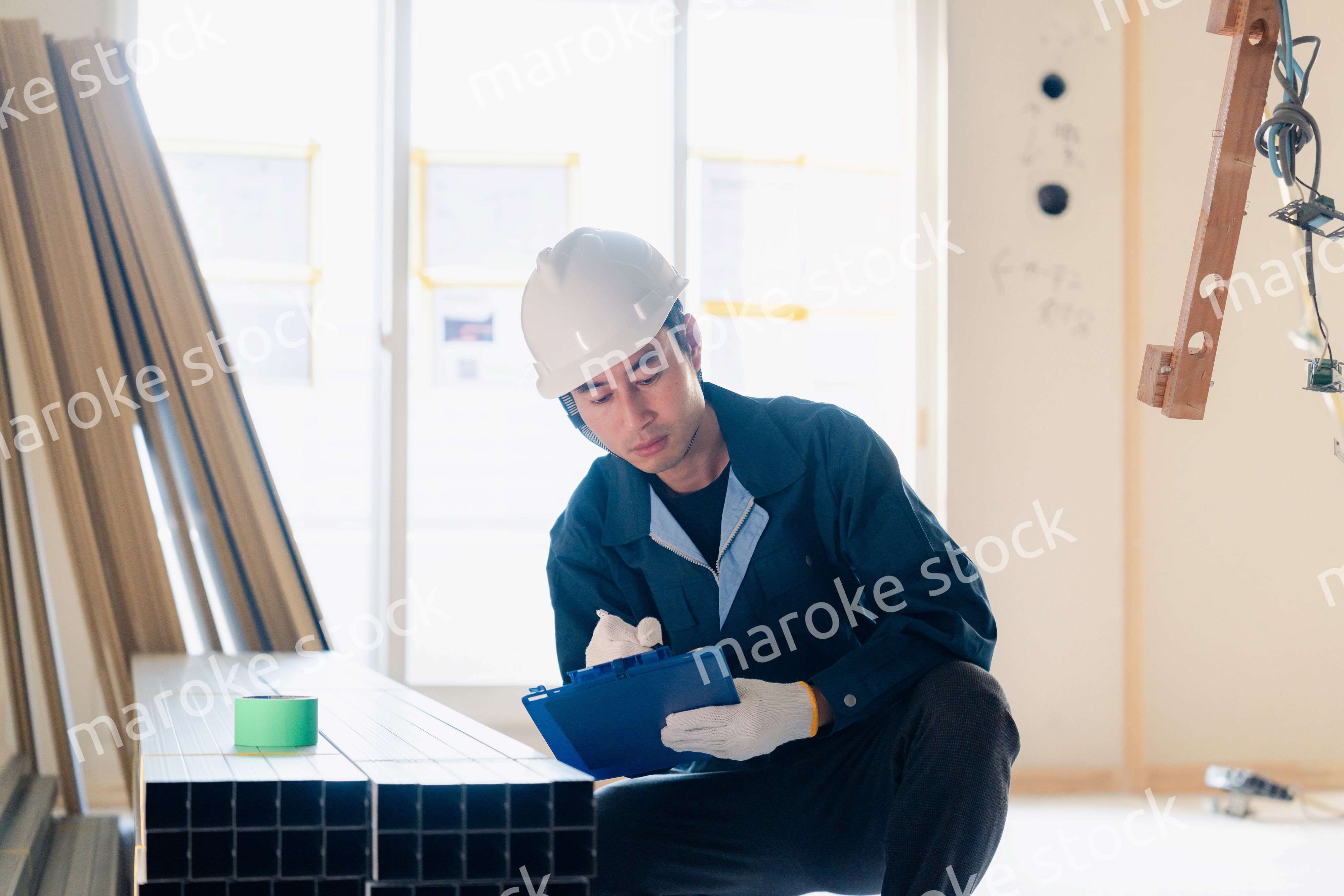 建設現場で資材の確認をする大工