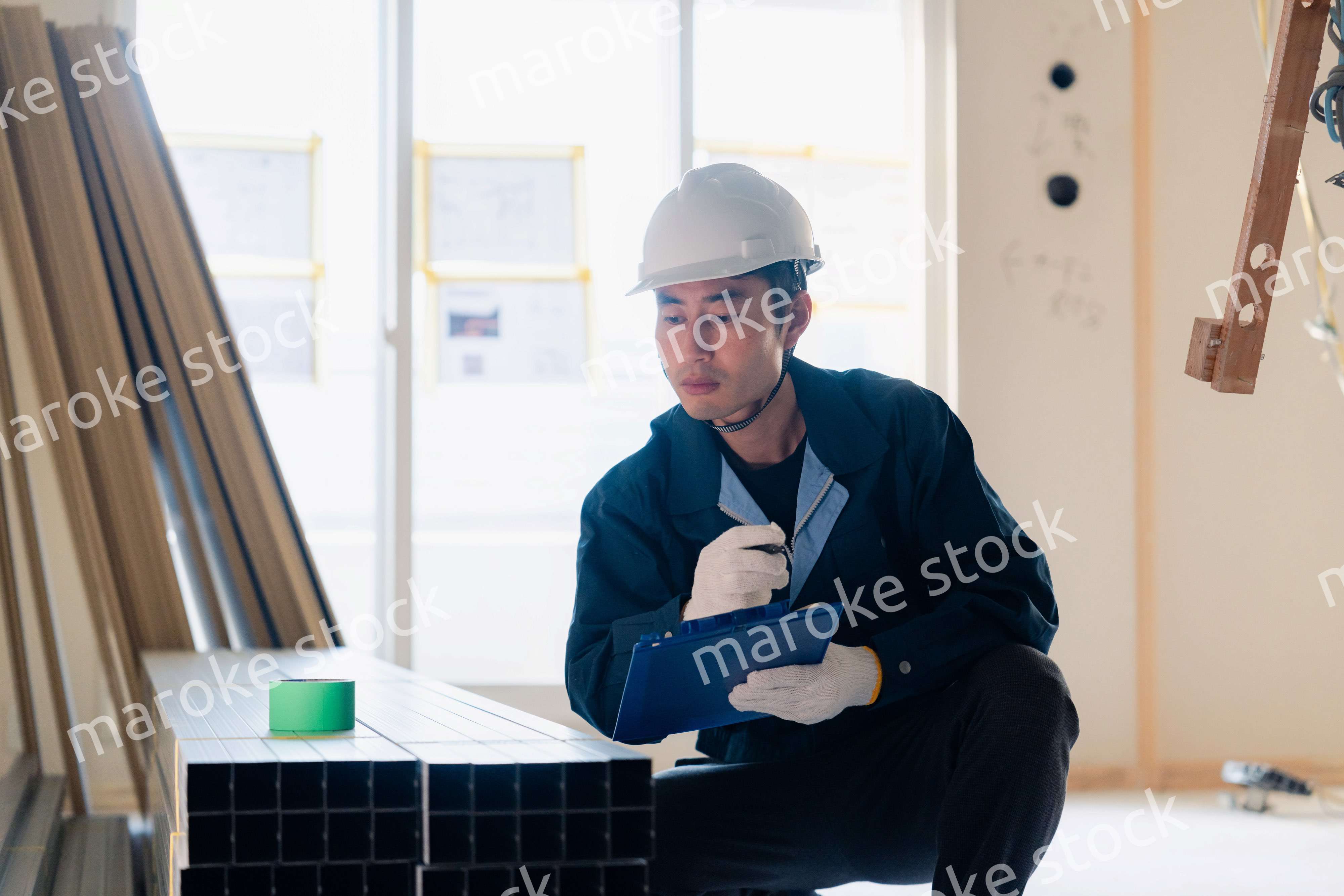 建設現場で資材の確認をする大工