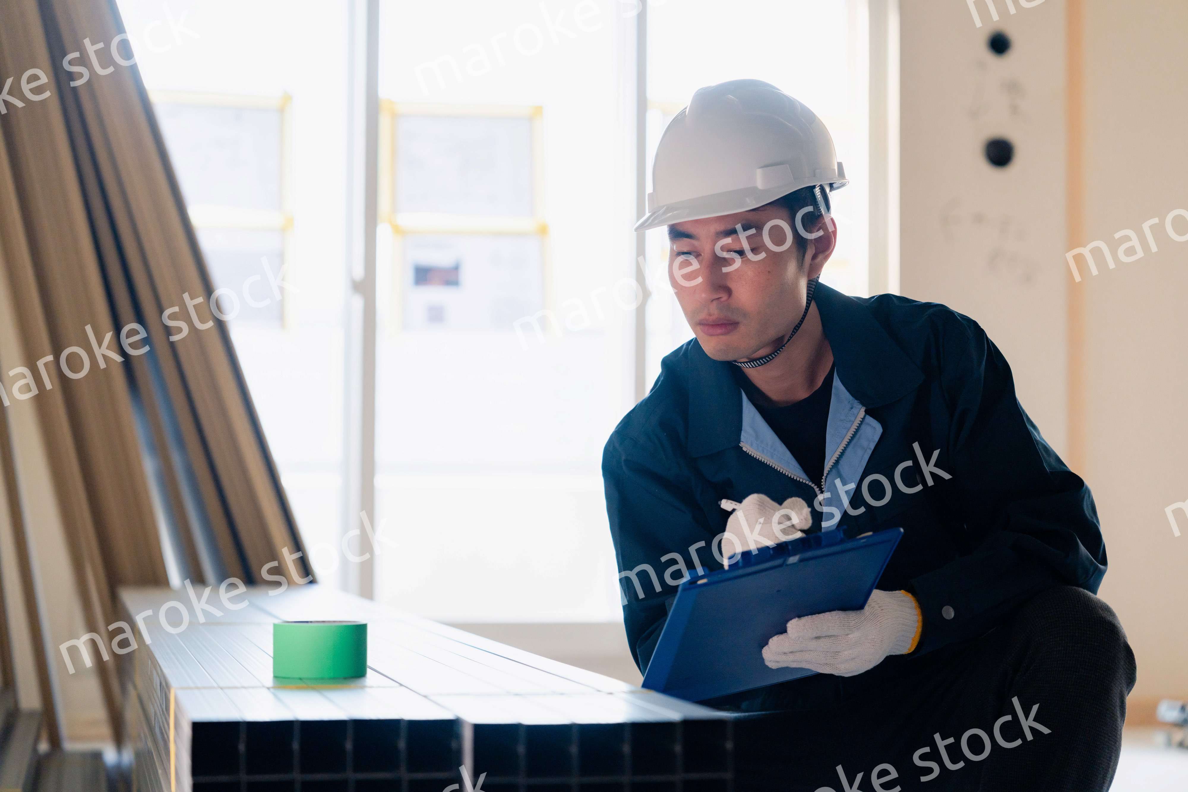 建設現場で資材の確認をする大工