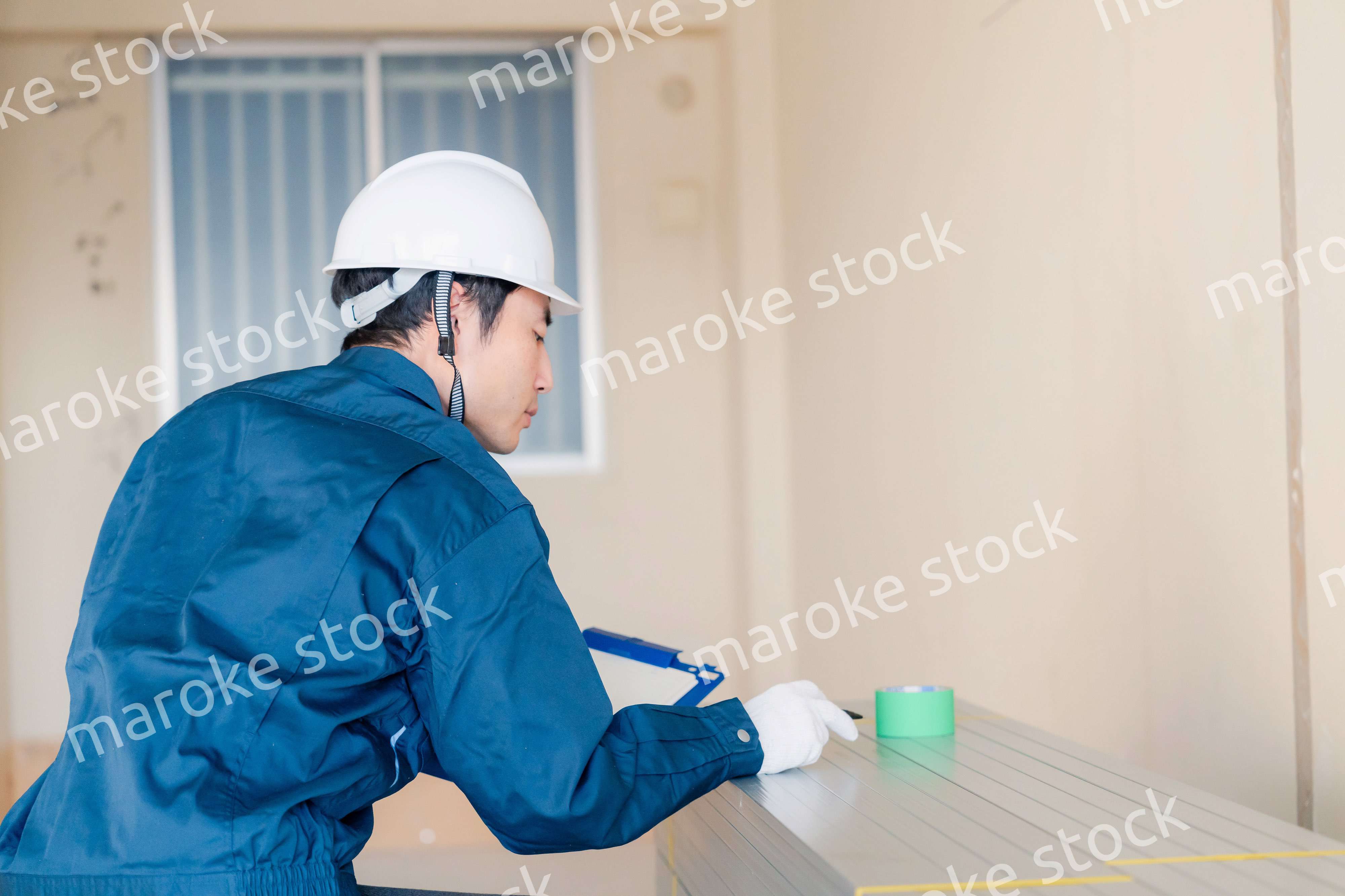 建設現場で資材の確認をする大工