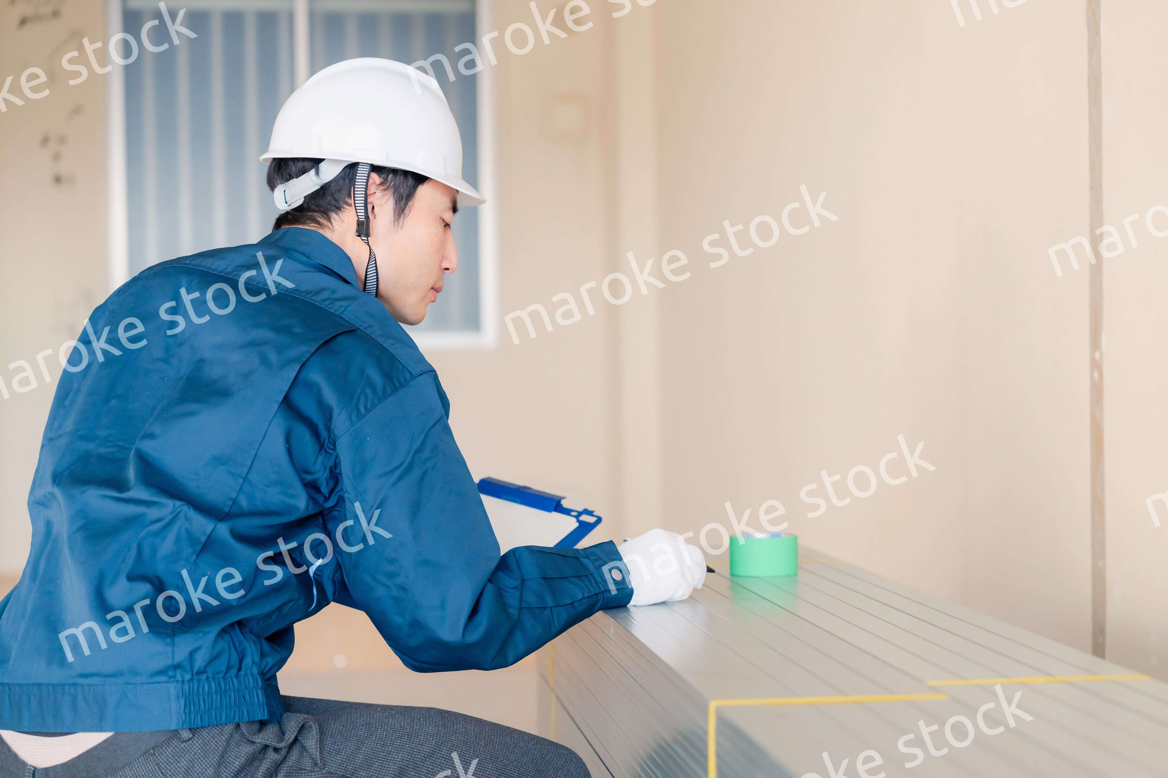 建設現場で資材の確認をする大工