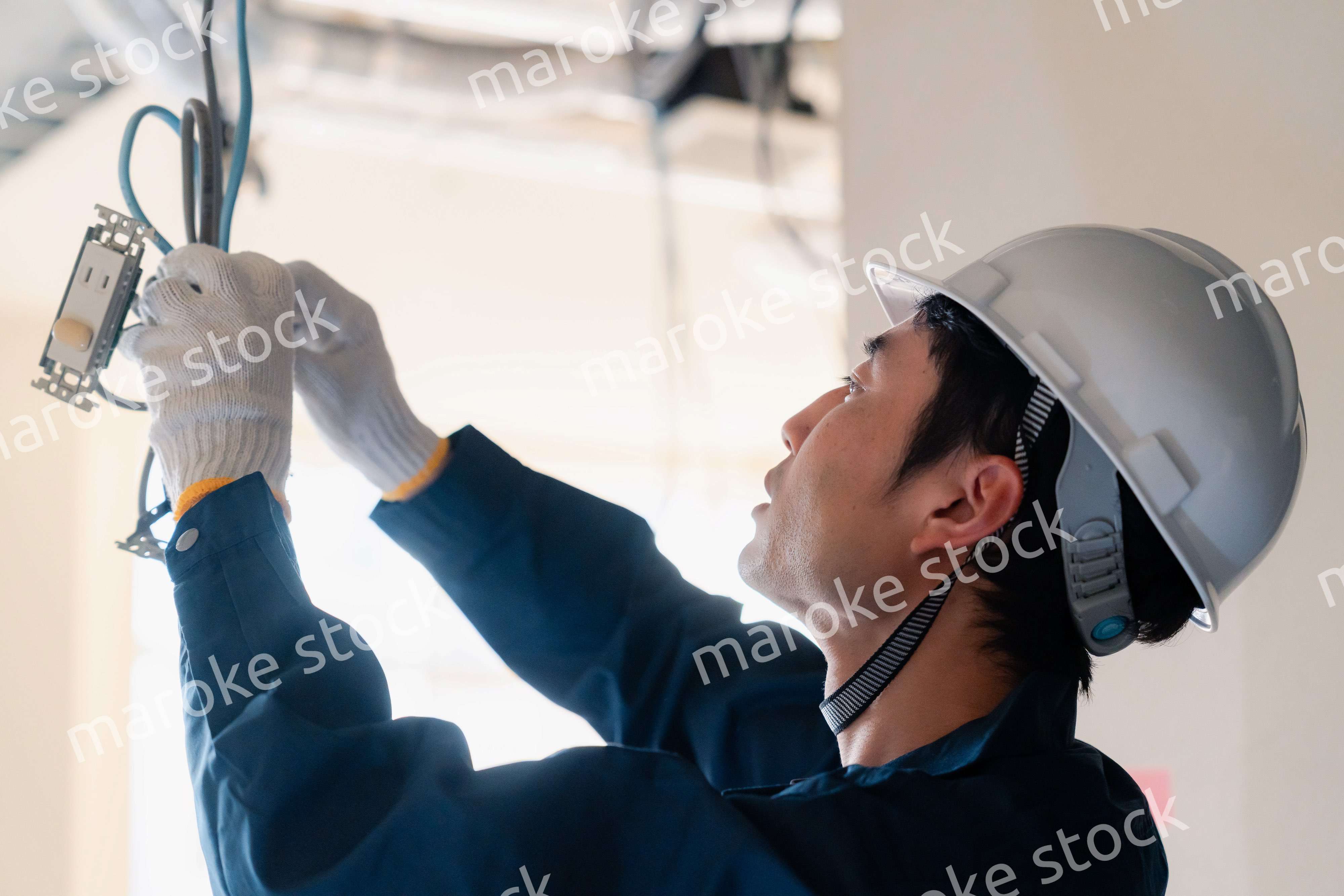 建築現場で配線工事をする電気工事士