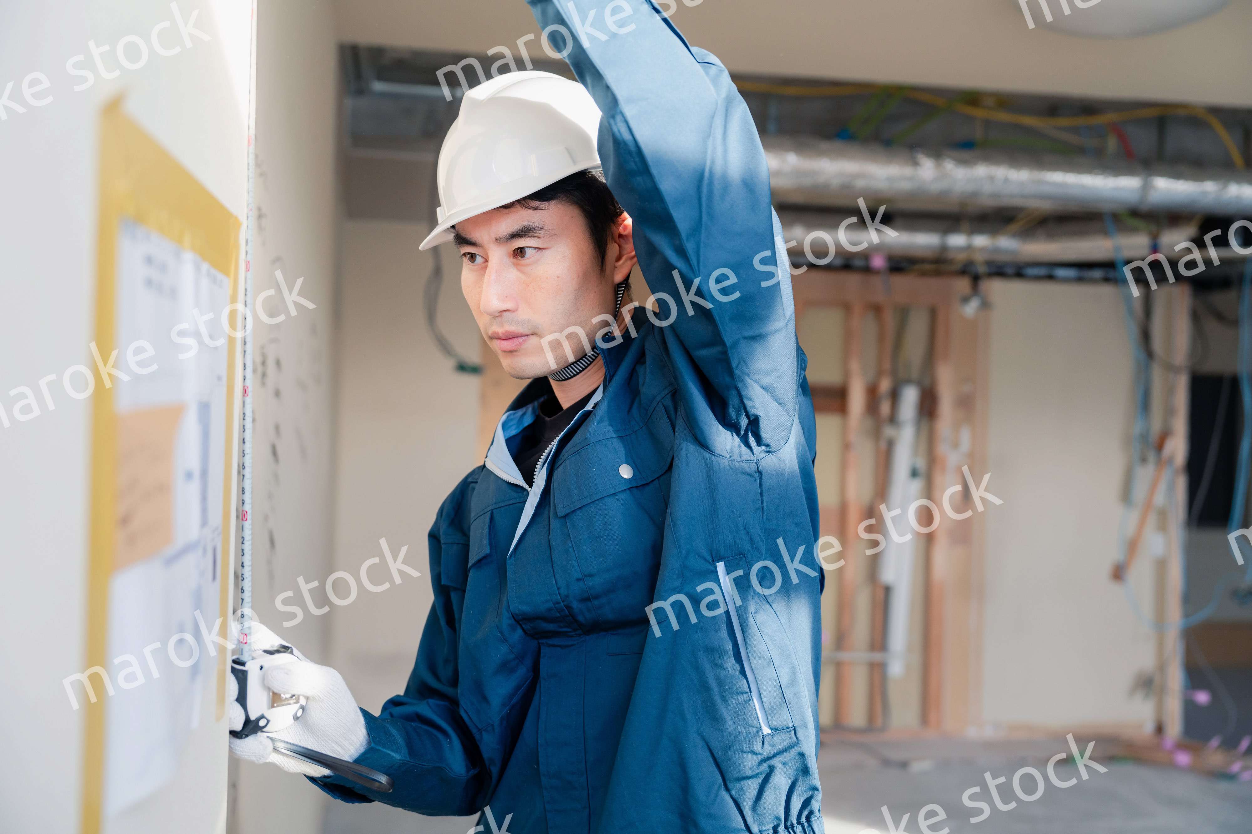 建設現場で採寸をする大工さん