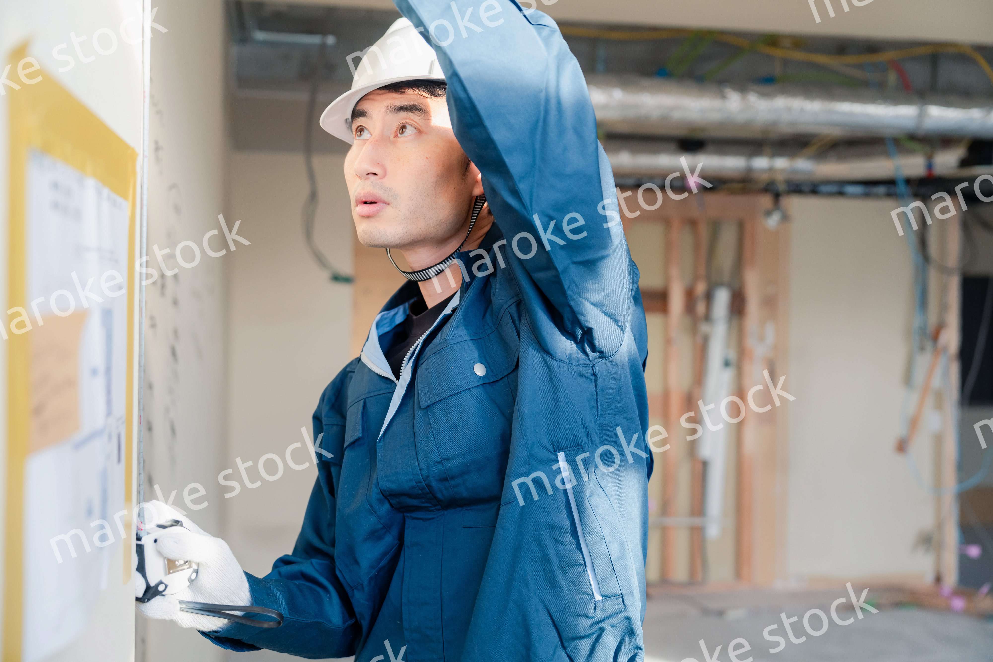 建設現場で採寸をする大工さん