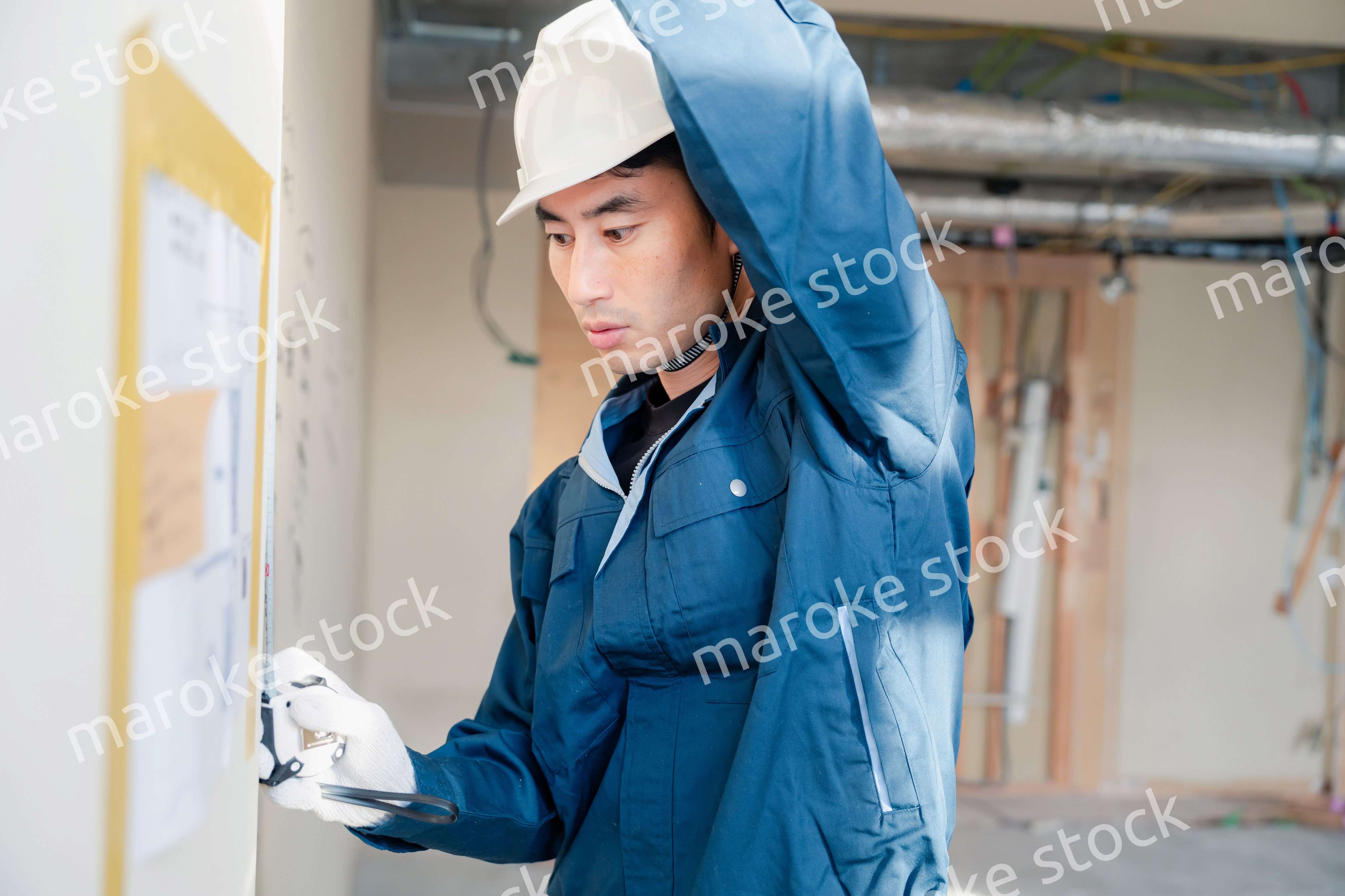 建設現場で採寸をする大工さん