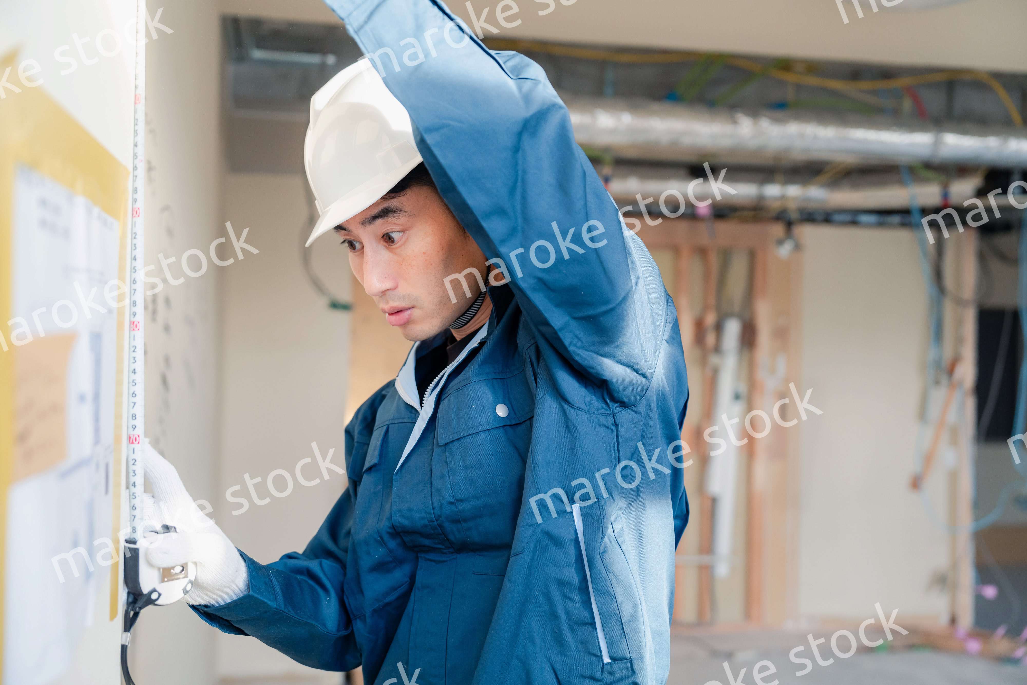 建設現場で採寸をする大工さん