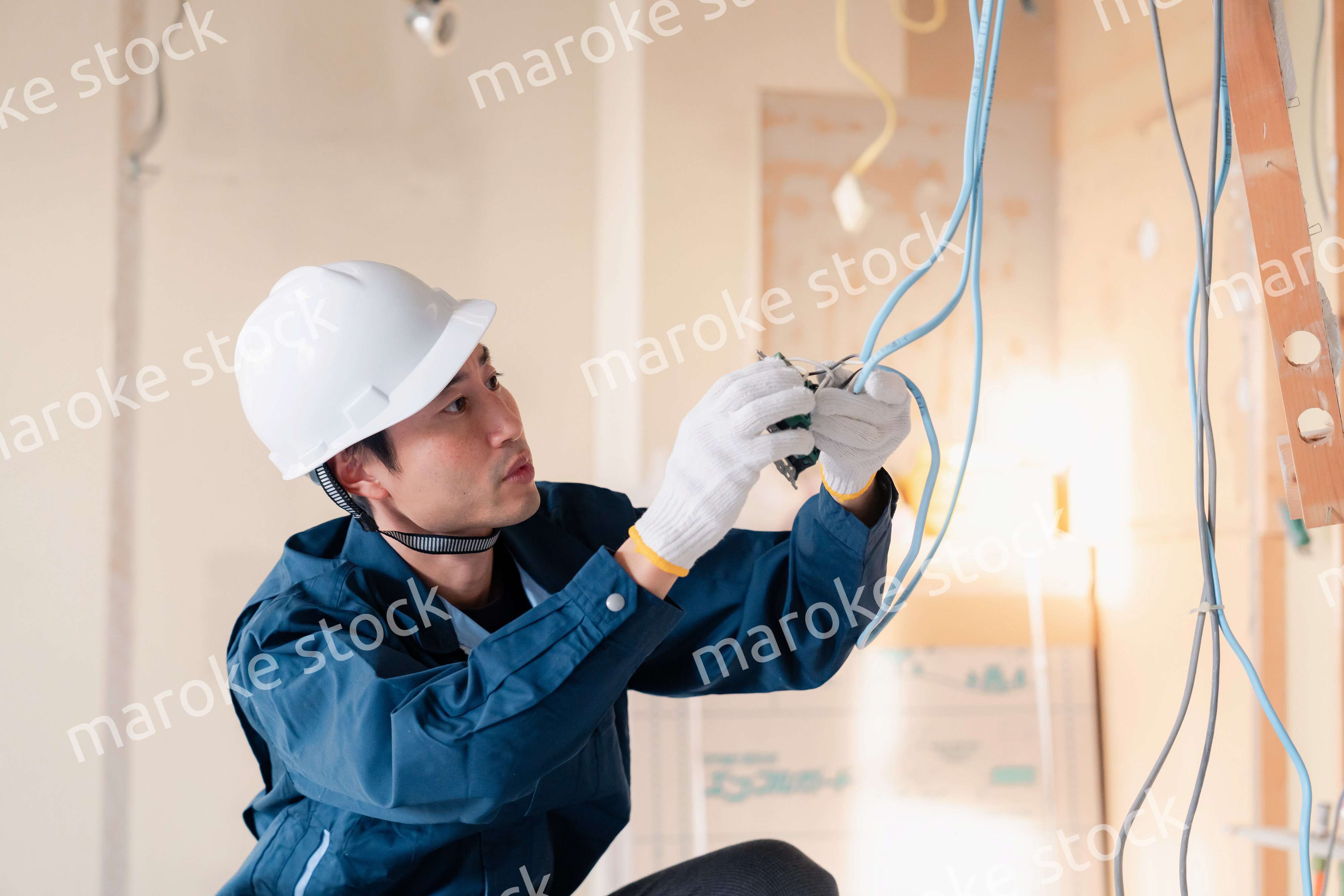 建築現場で配線工事をする電気工事士