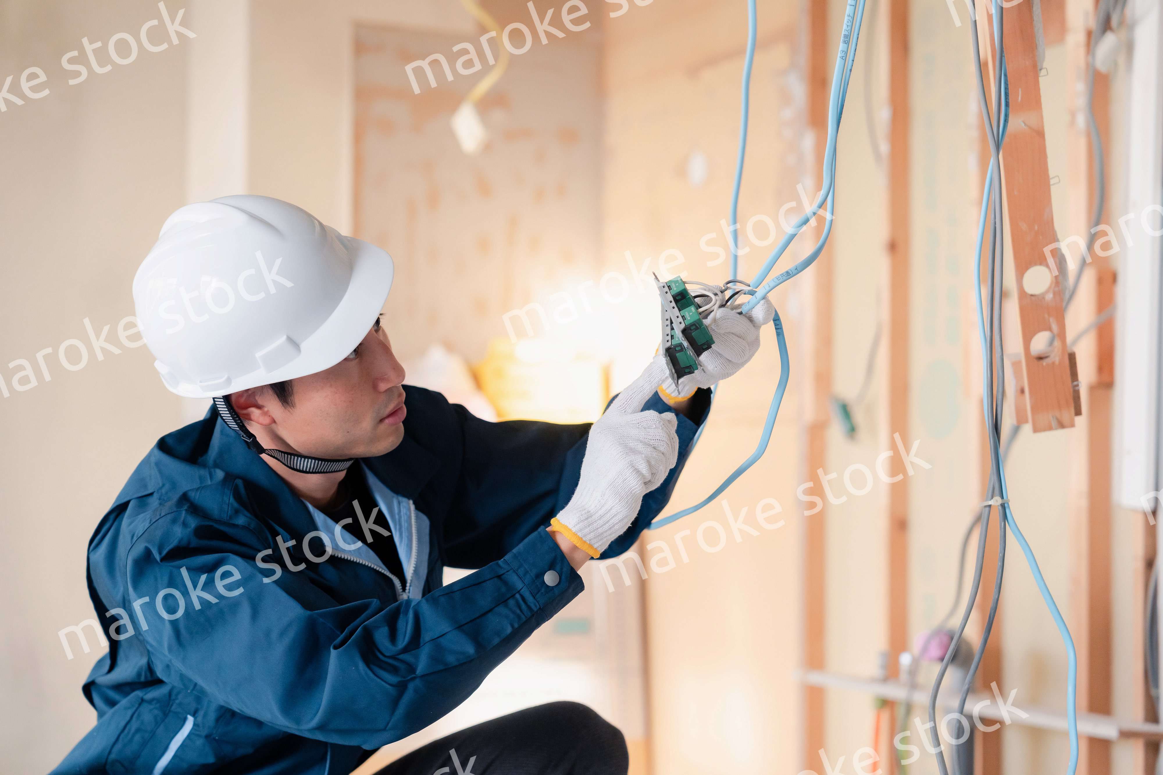 建築現場で配線工事をする電気工事士