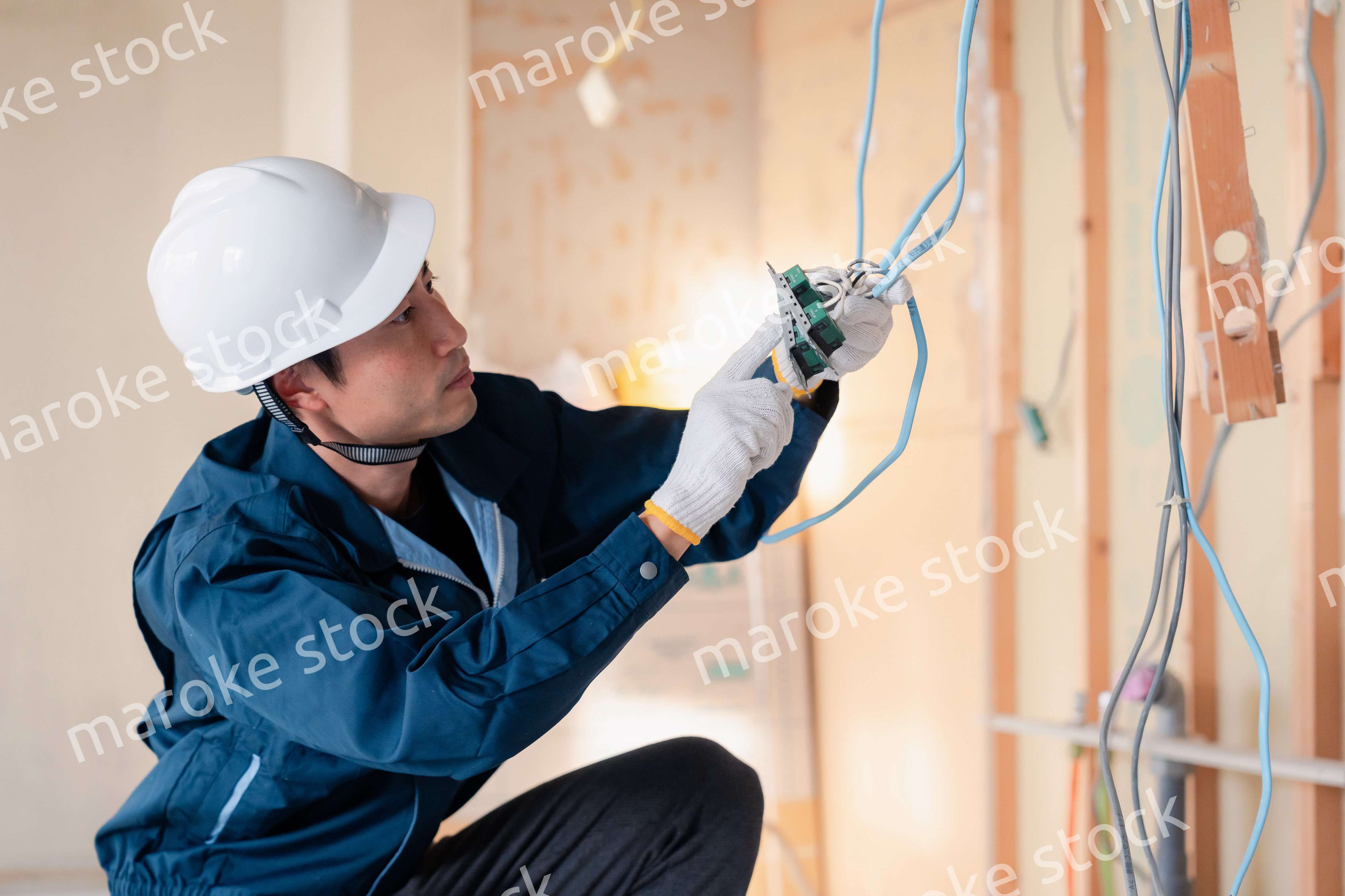 建築現場で配線工事をする電気工事士