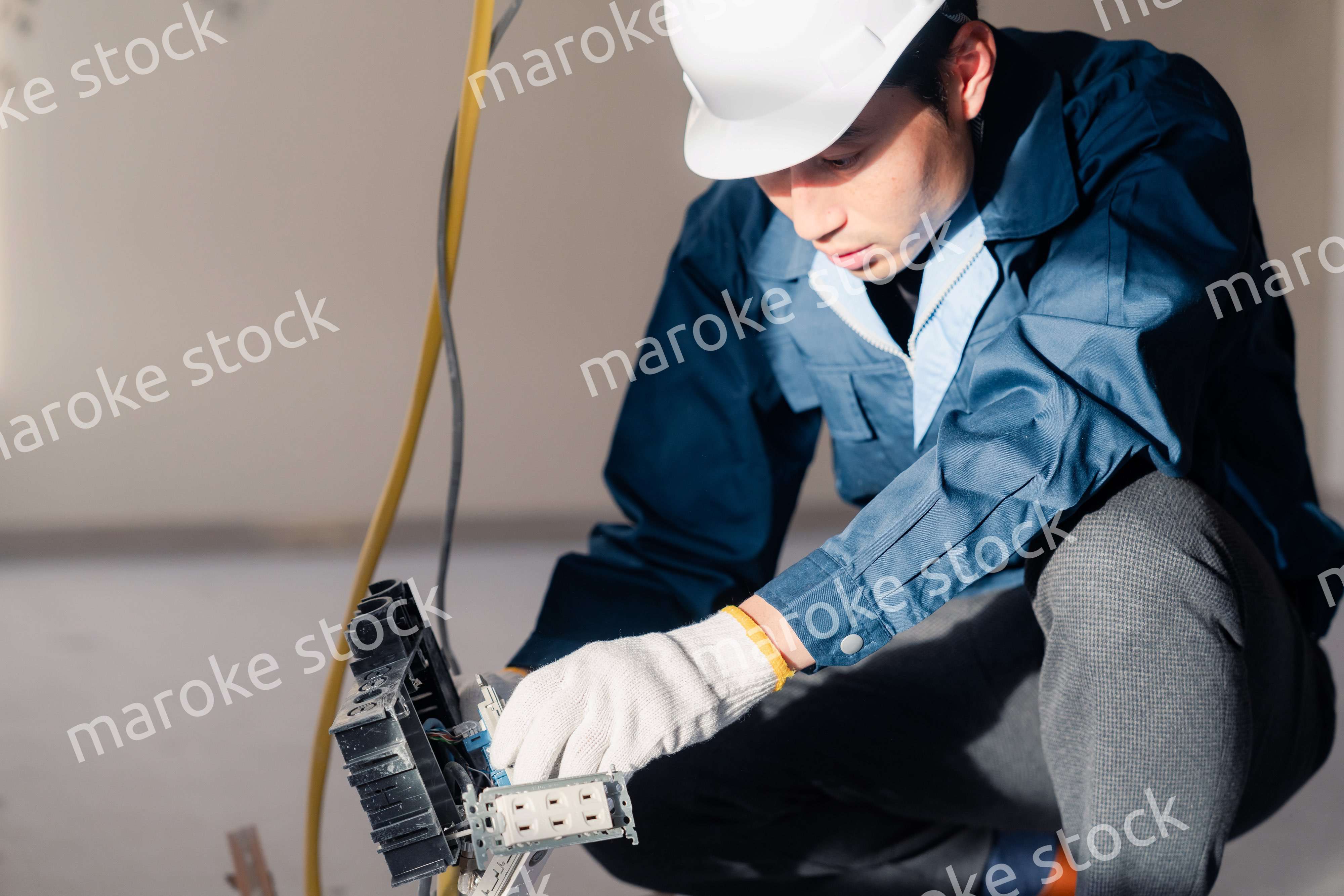 建築現場で配線工事をする電気工事士