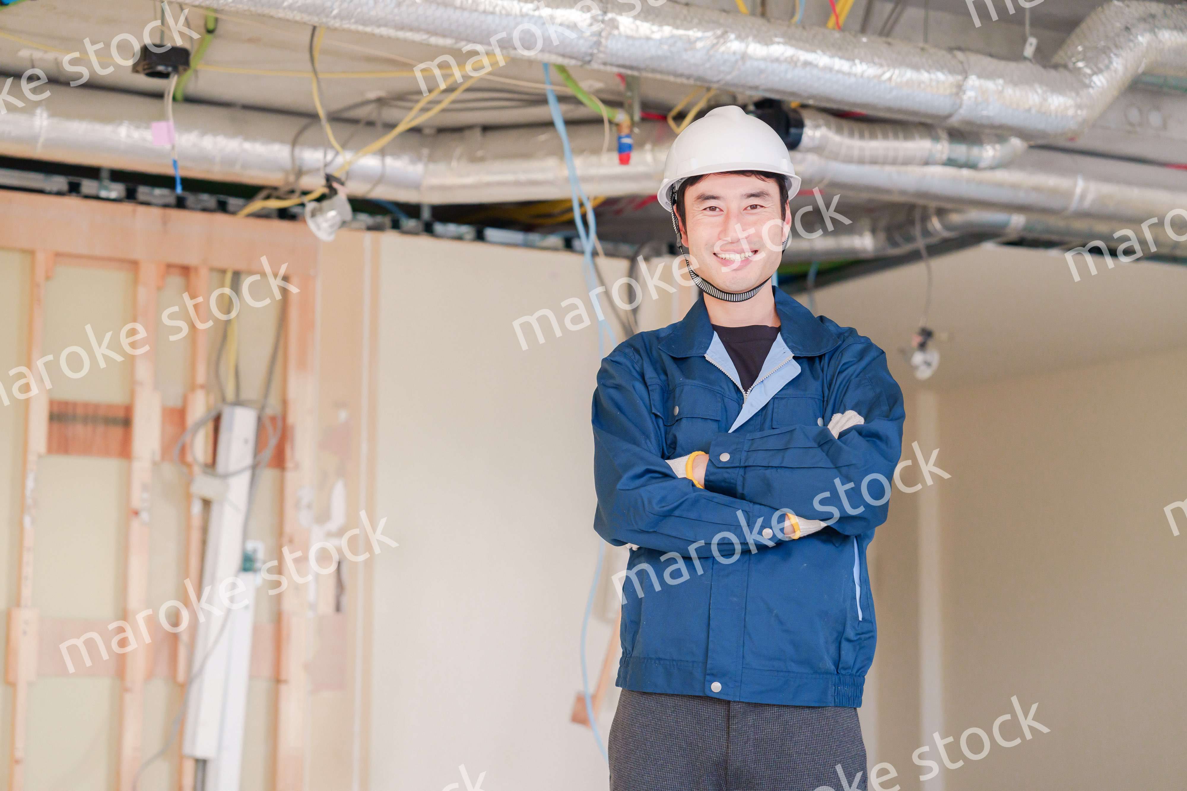 工事現場で腕を組む男性の職人