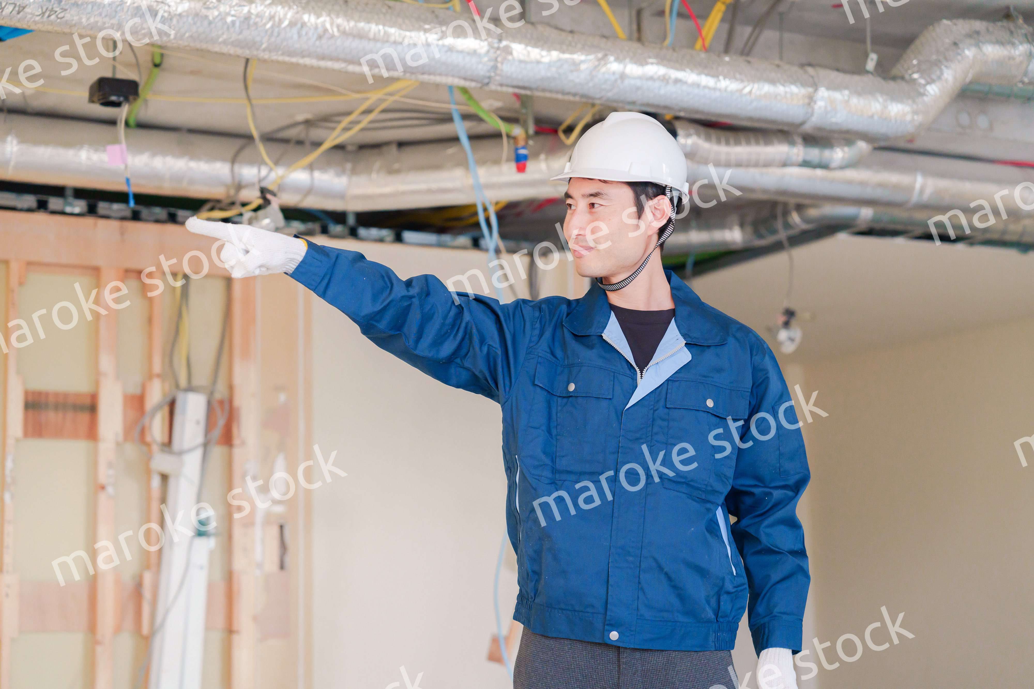 指差しをして安全確認をする男性の建築作業員