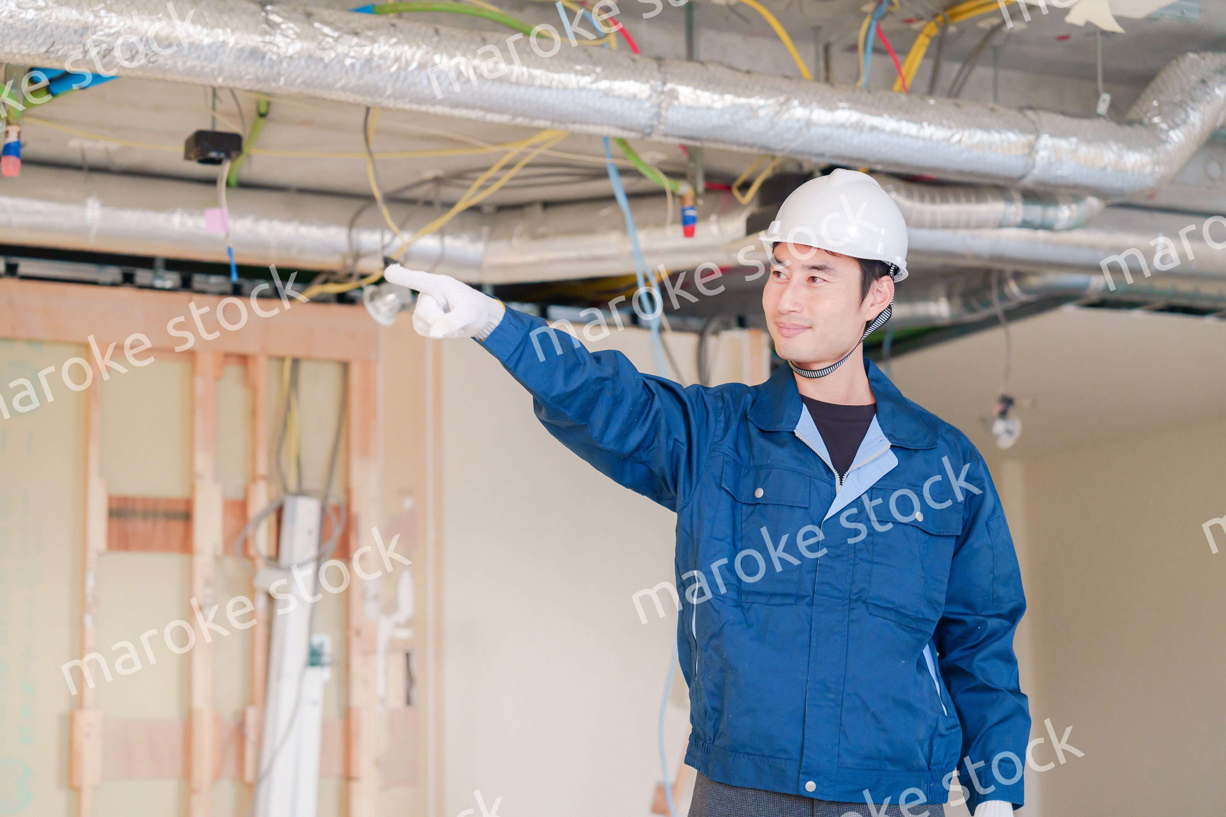 指差しをして安全確認をする男性の建築作業員